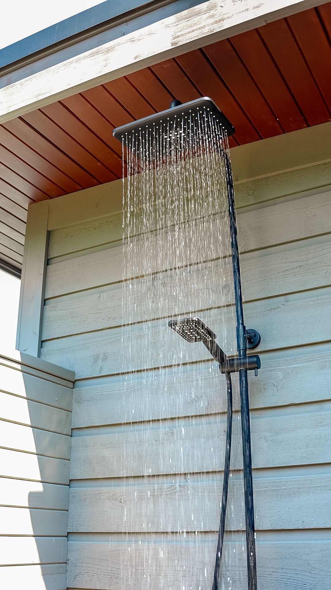 A shower head is hanging from the ceiling of a building.