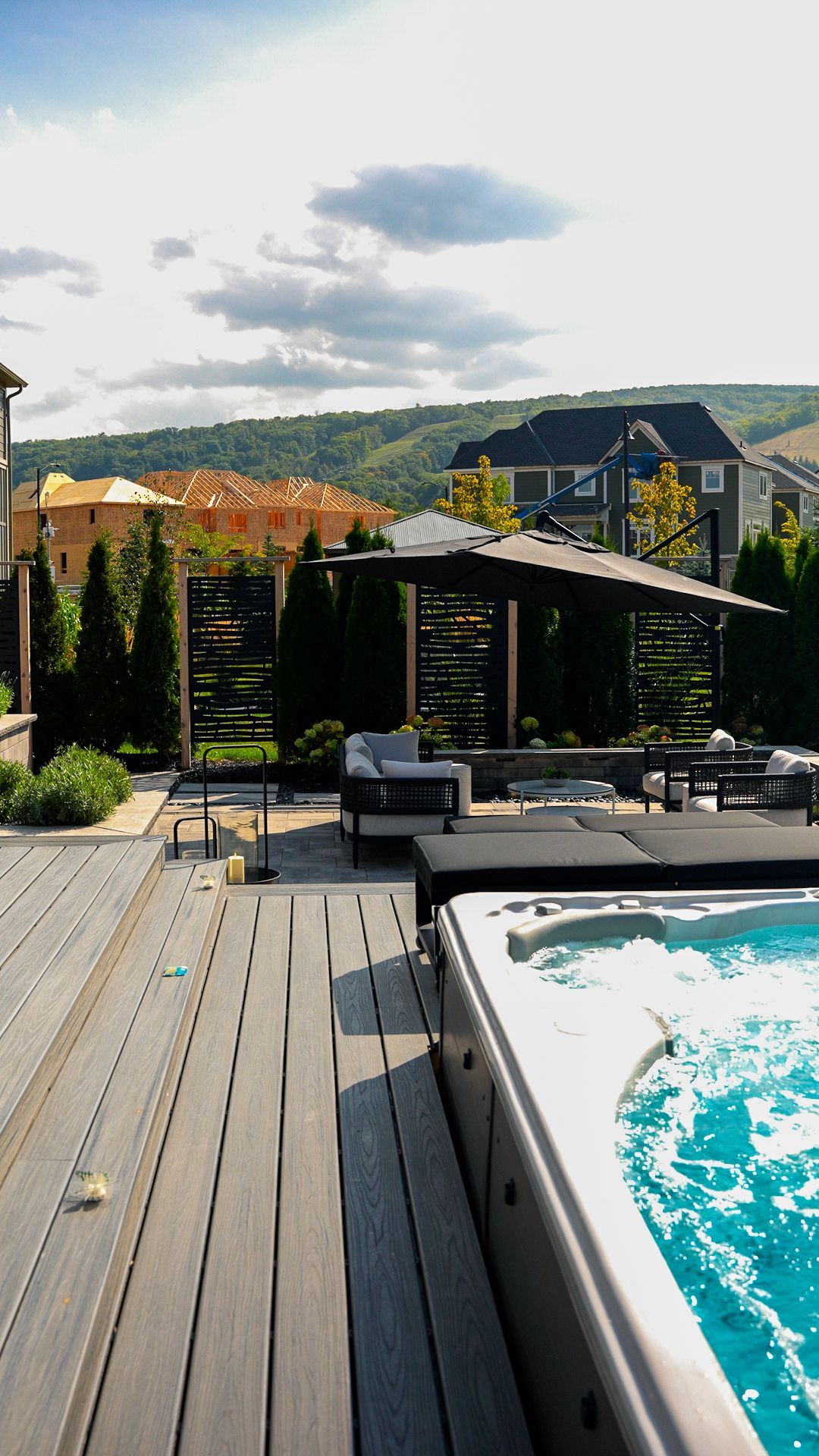 A hot tub is sitting on a wooden deck next to a swimming pool.