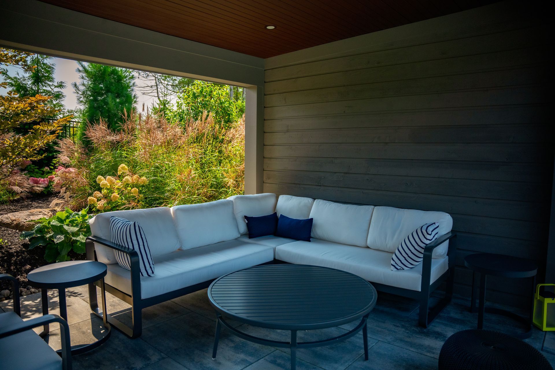 A patio with a sectional couch and a round table.