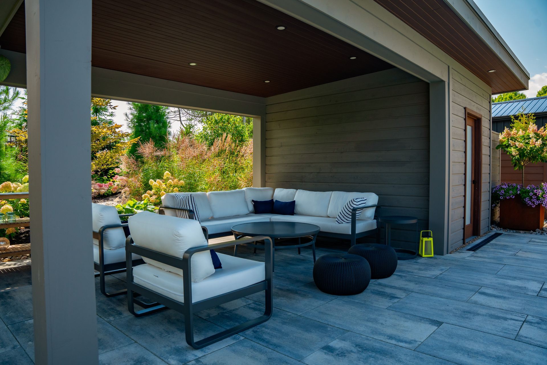 A patio with a couch and chairs under a gazebo.