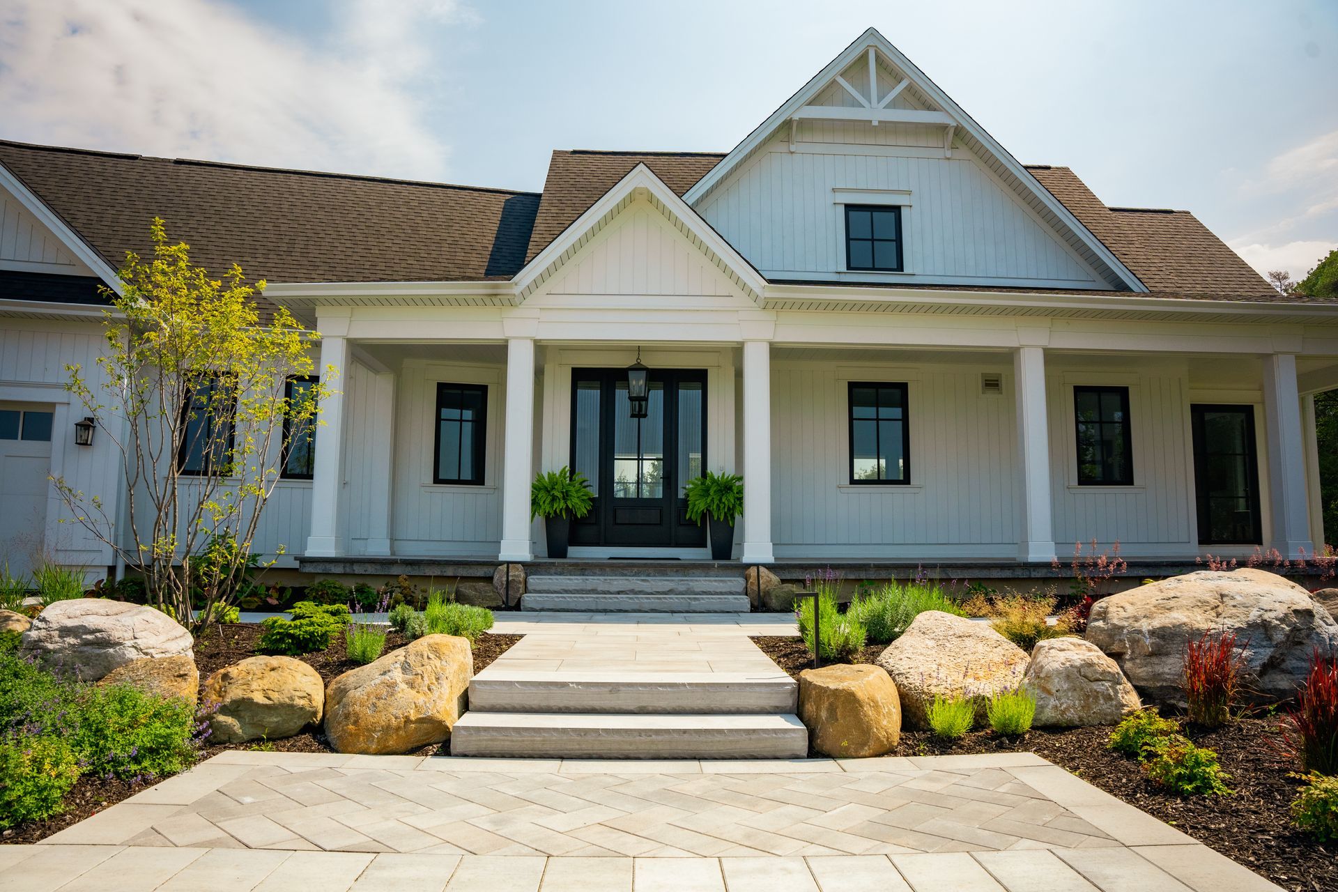 A large white house with a large porch and steps leading to it.