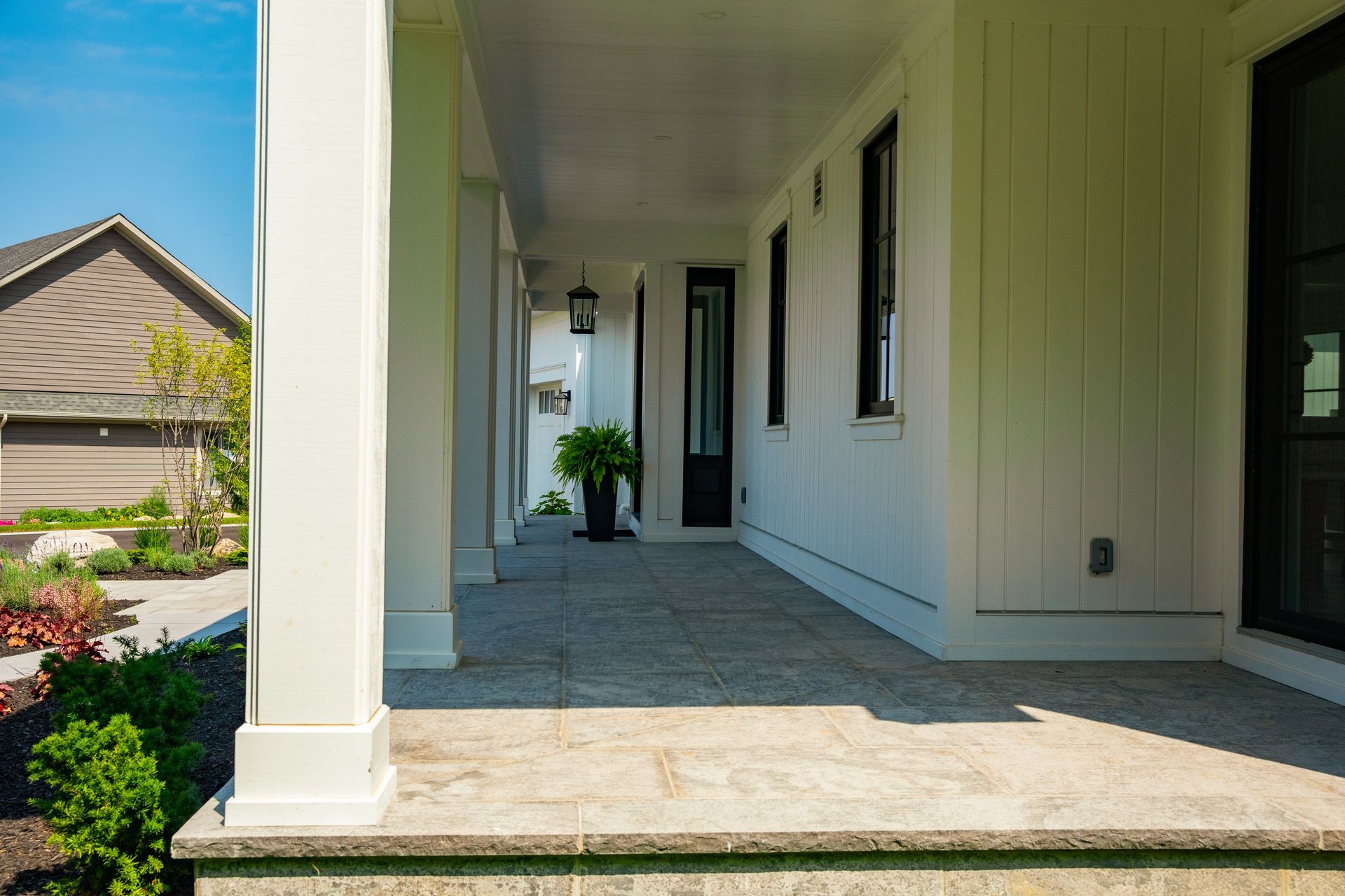 A white house with a porch and a black door.