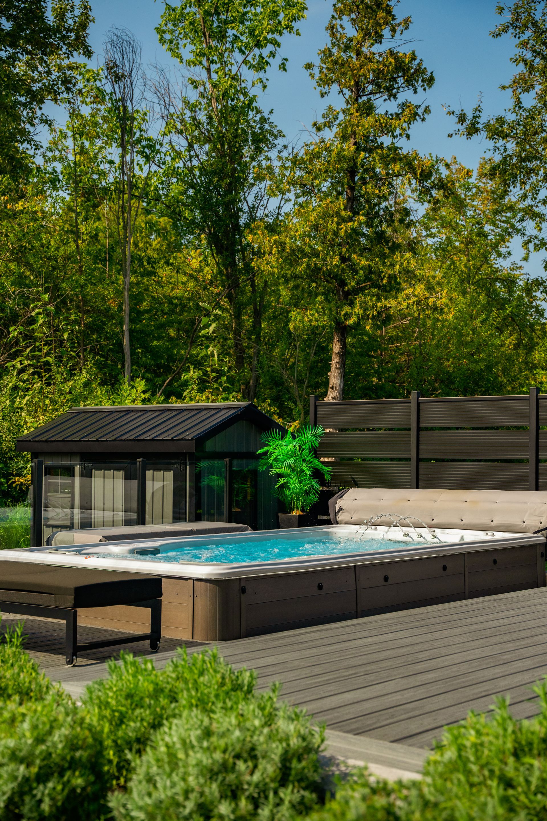 A large swimming pool with a gazebo in the backyard surrounded by trees.