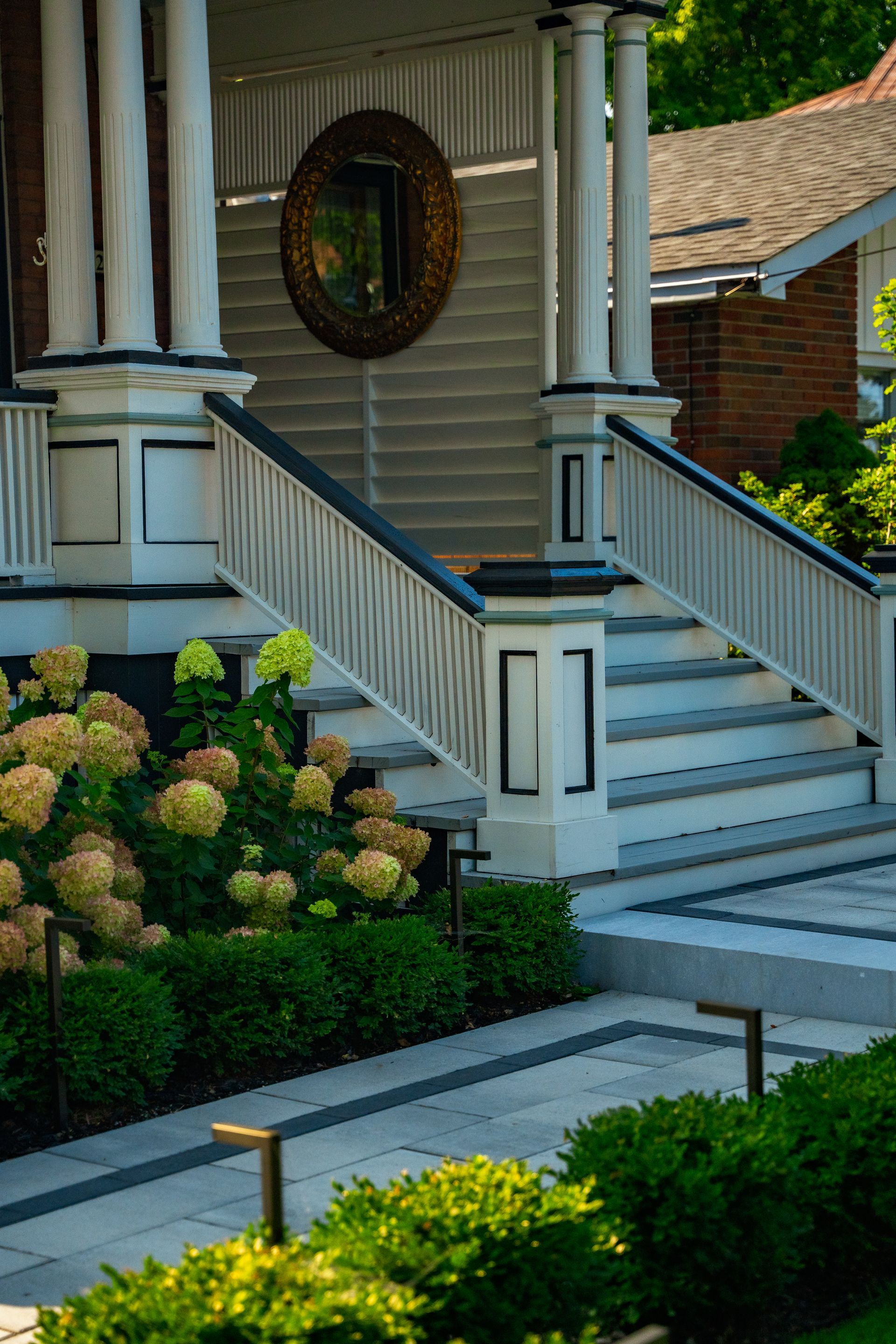 A porch with stairs leading up to it and a mirror on the wall.