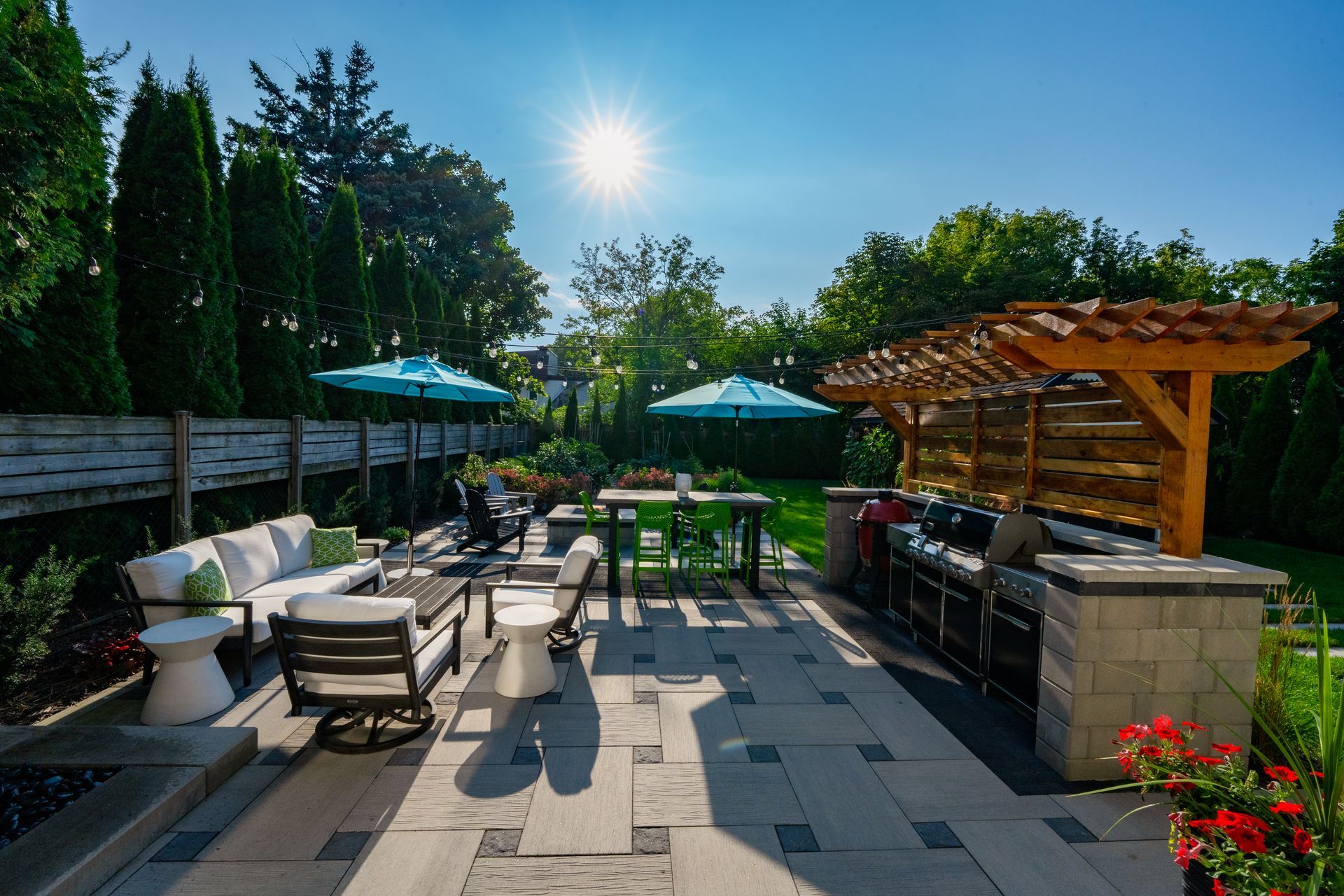A patio with a grill and umbrellas on a sunny day.
