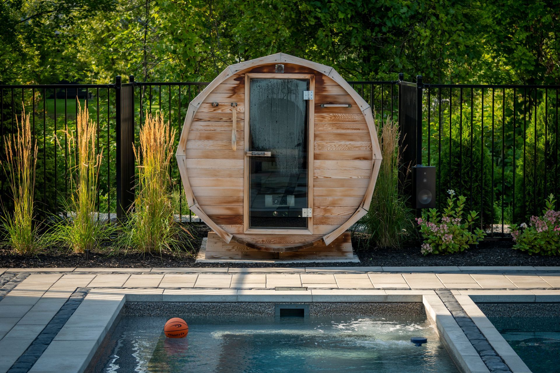 A wooden sauna is sitting next to a swimming pool.