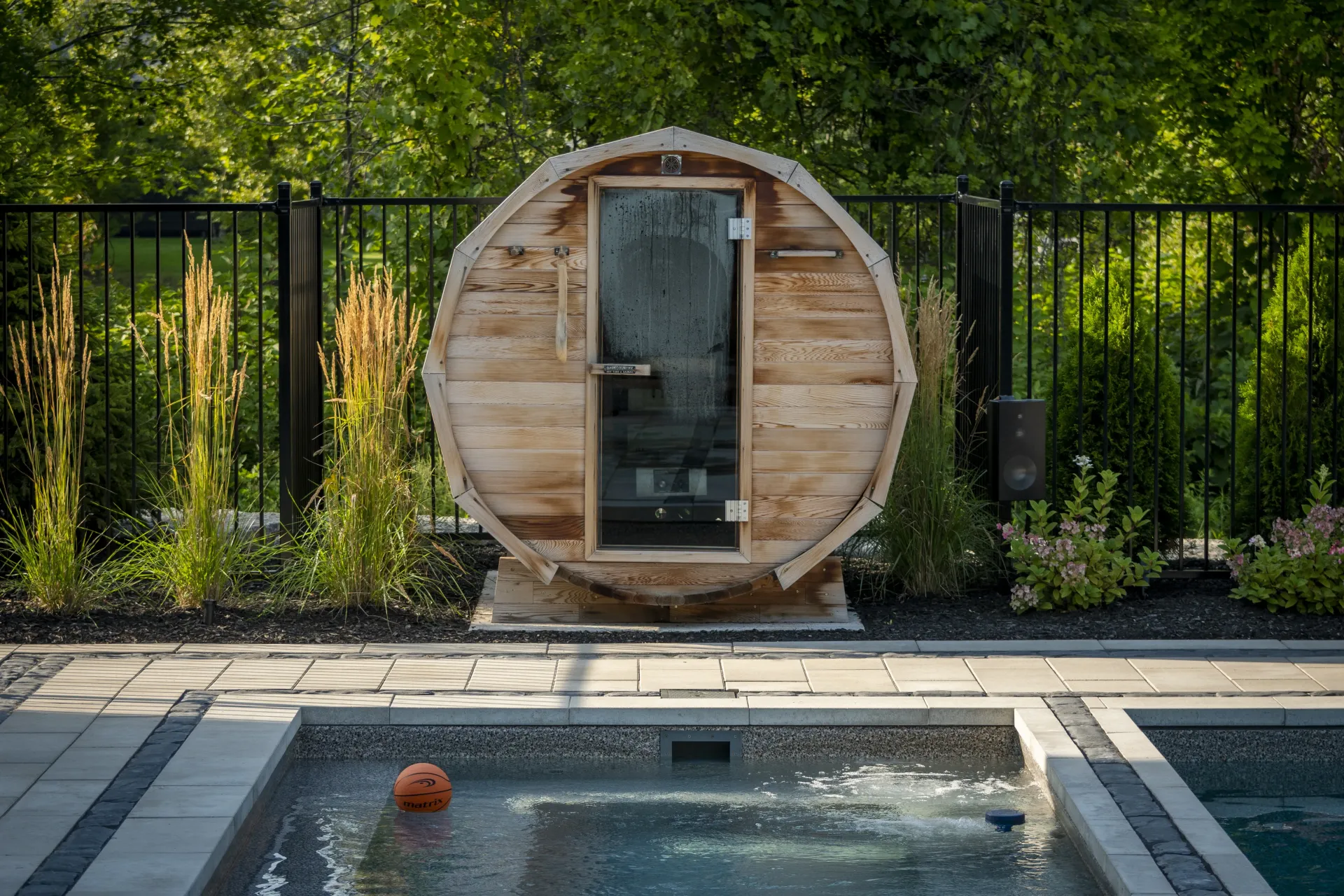A wooden sauna is sitting next to a swimming pool.
