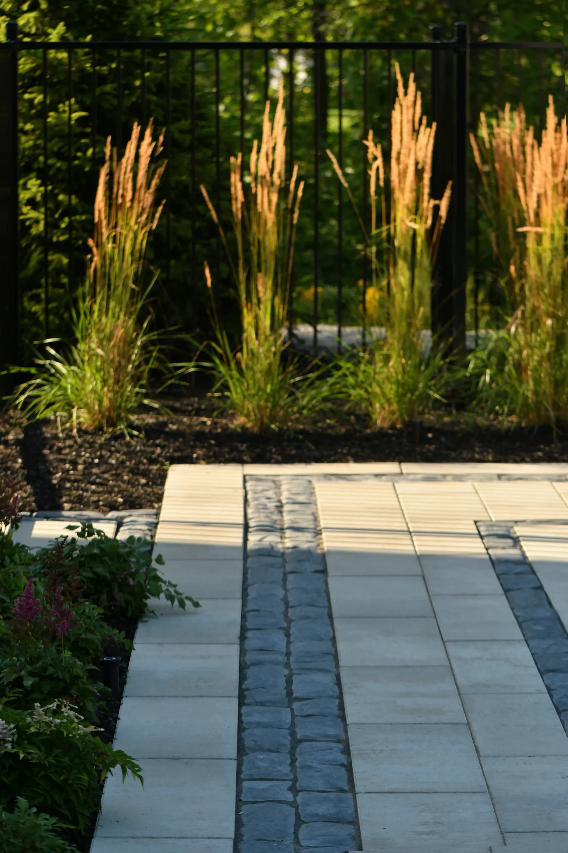 A patio with a fence and plants in the background