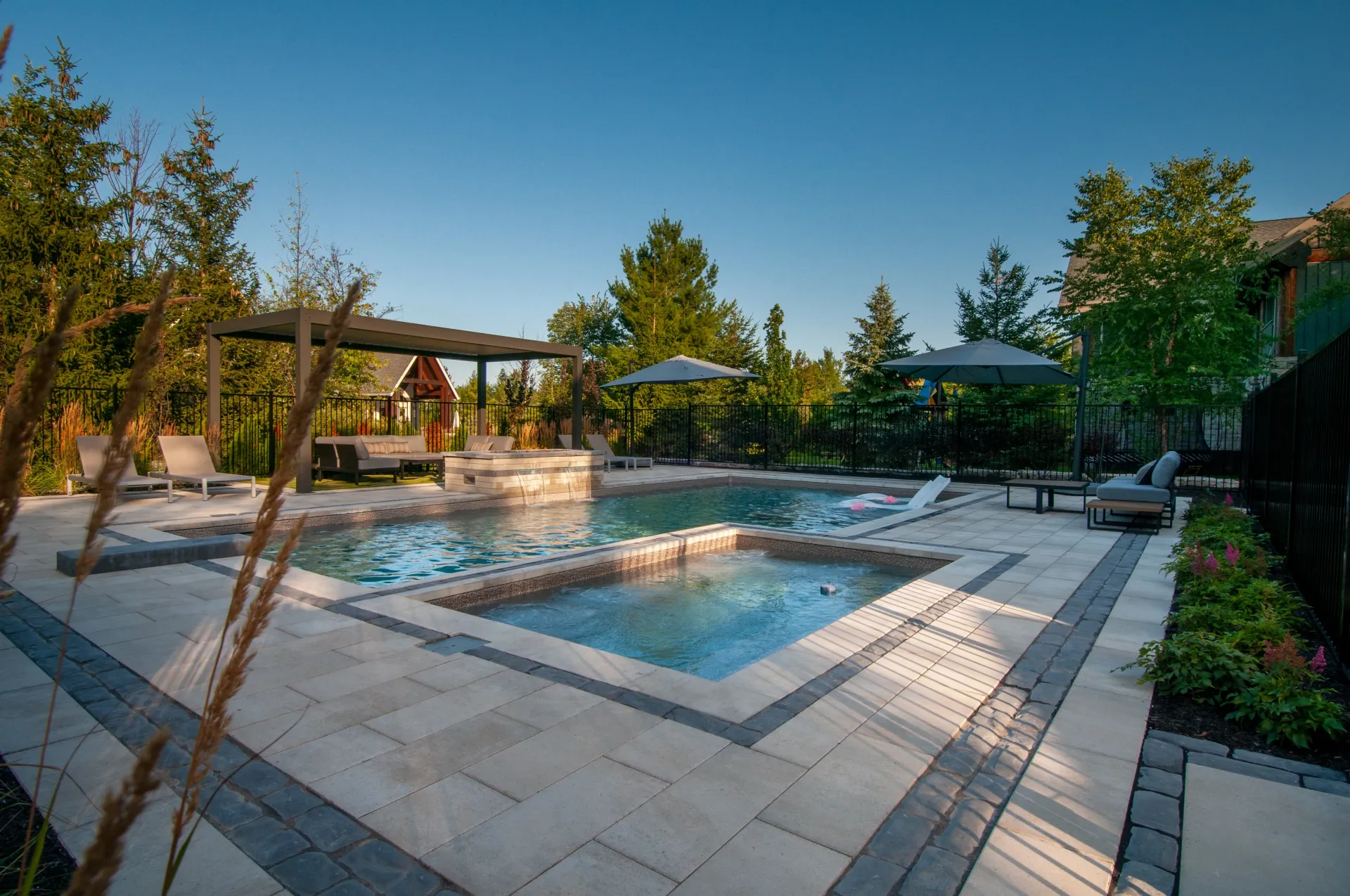 There is a large swimming pool and a hot tub in the backyard.