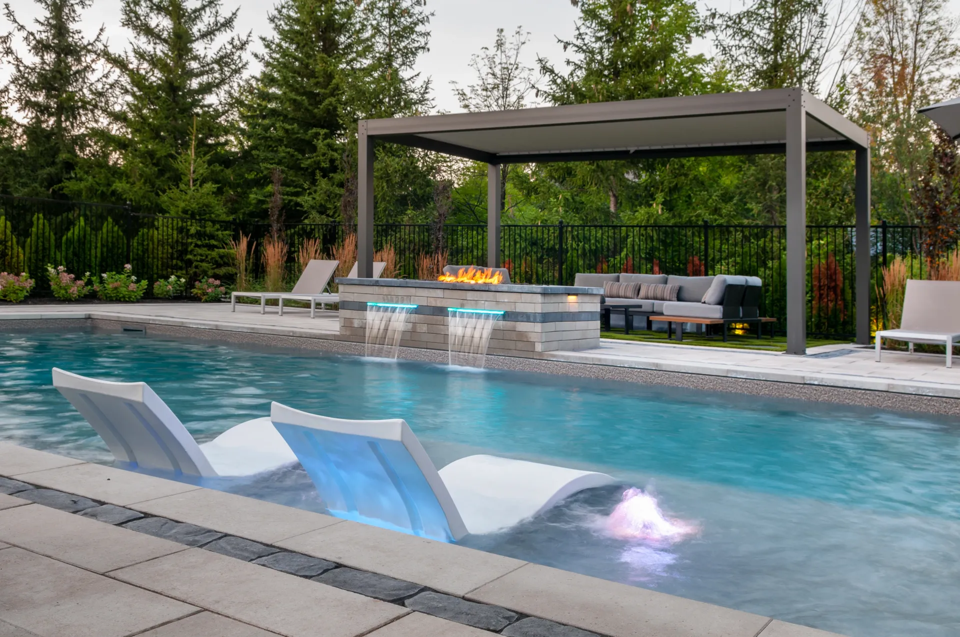 A large swimming pool with a gazebo and chairs around it.