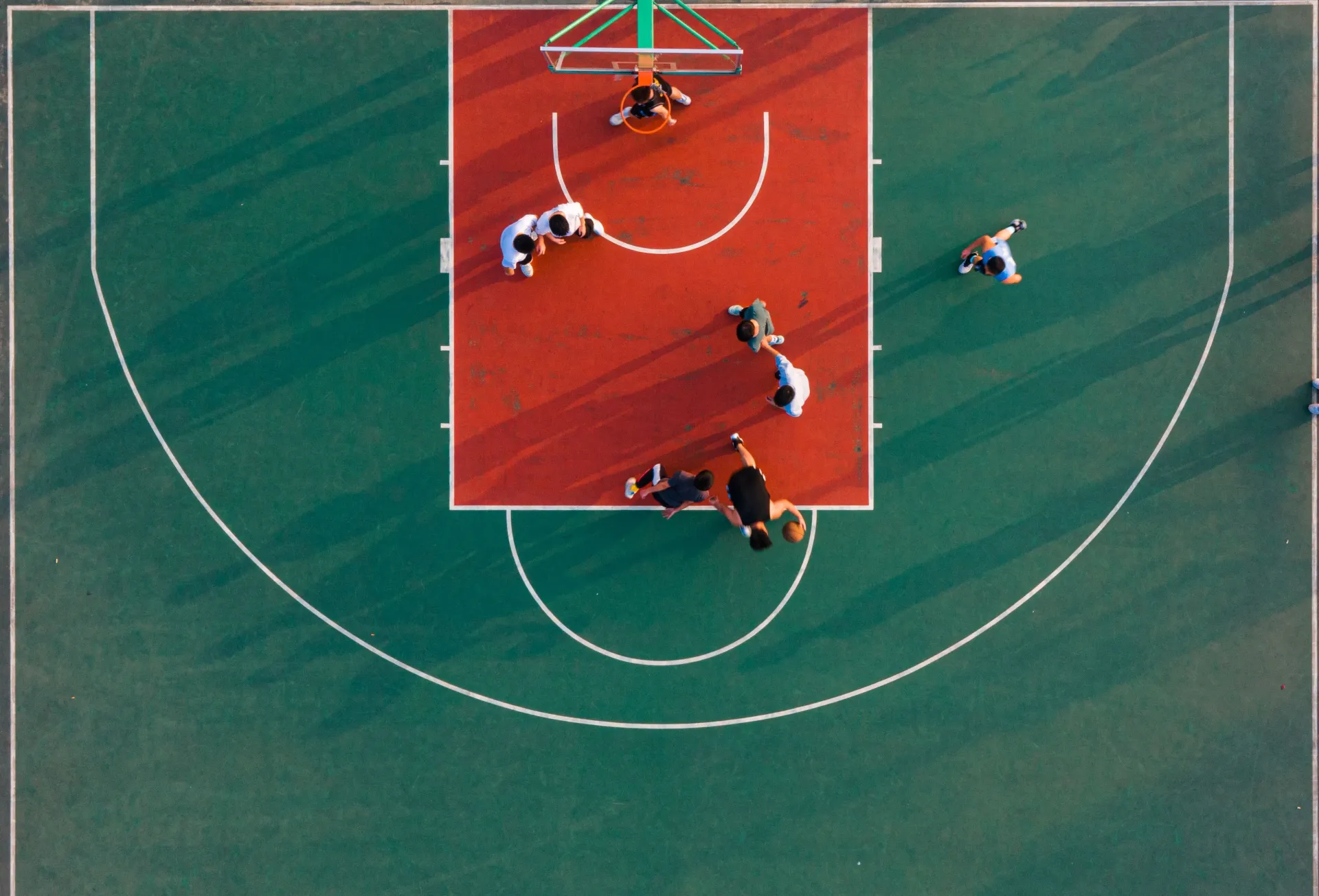 A group of people are playing basketball on a court.