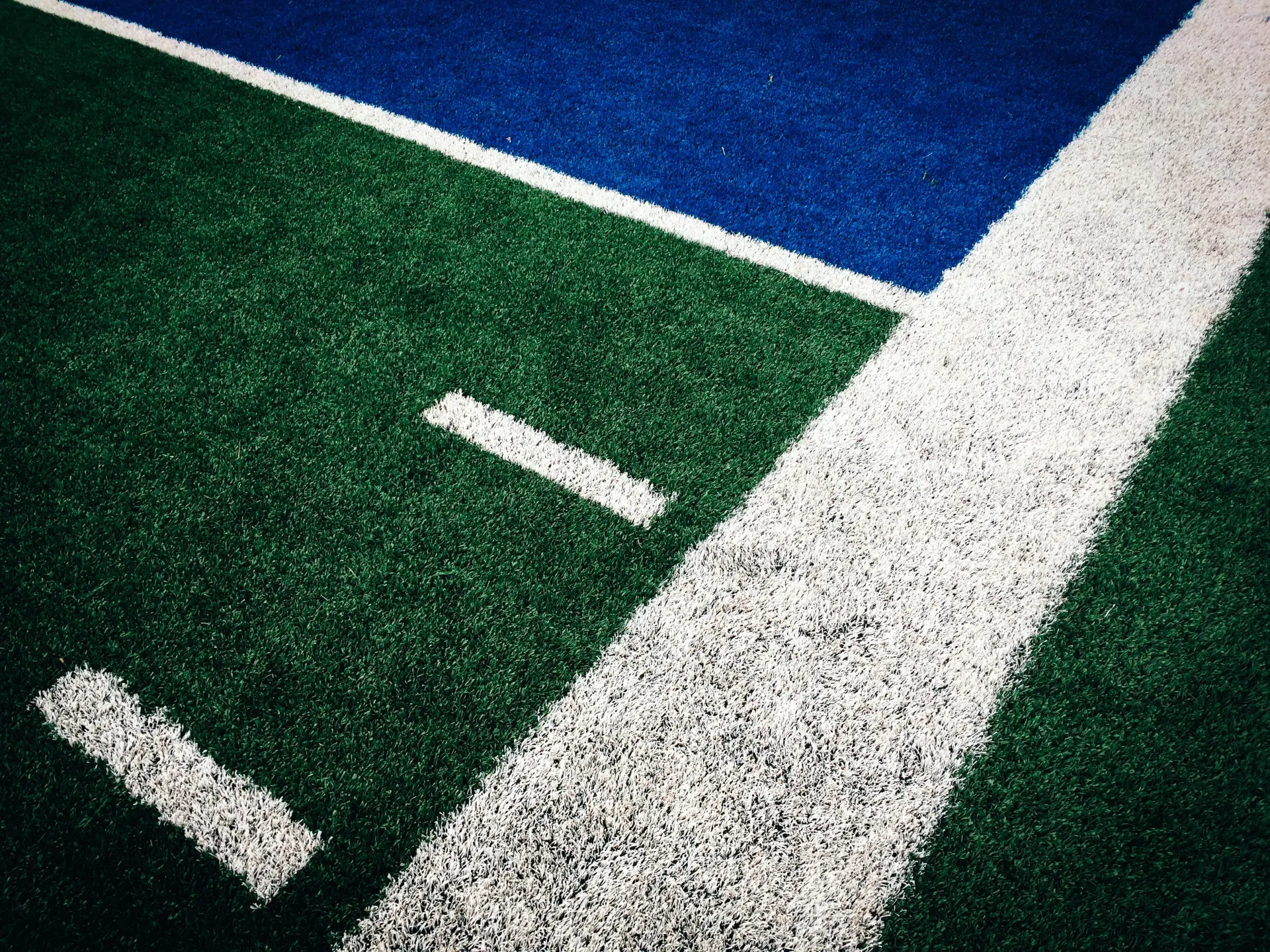 A green and blue tennis court with a white line
