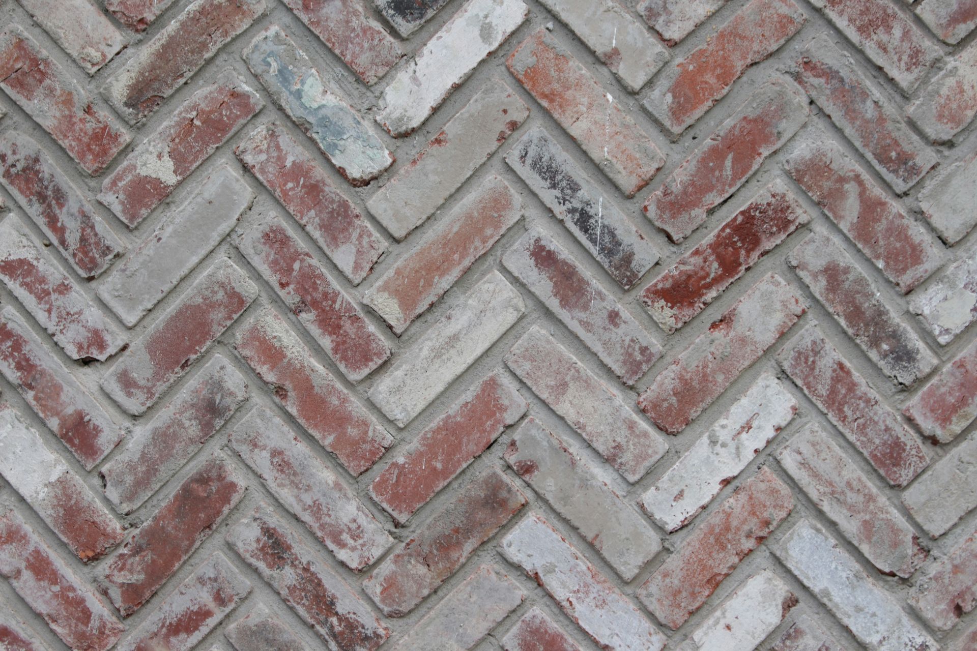 A close up of a brick wall with a herringbone pattern