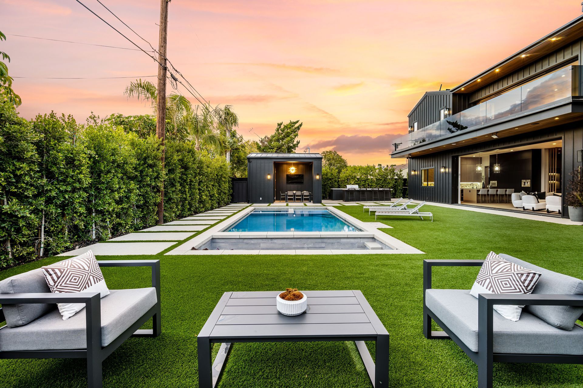There is a large swimming pool in the backyard of a house.