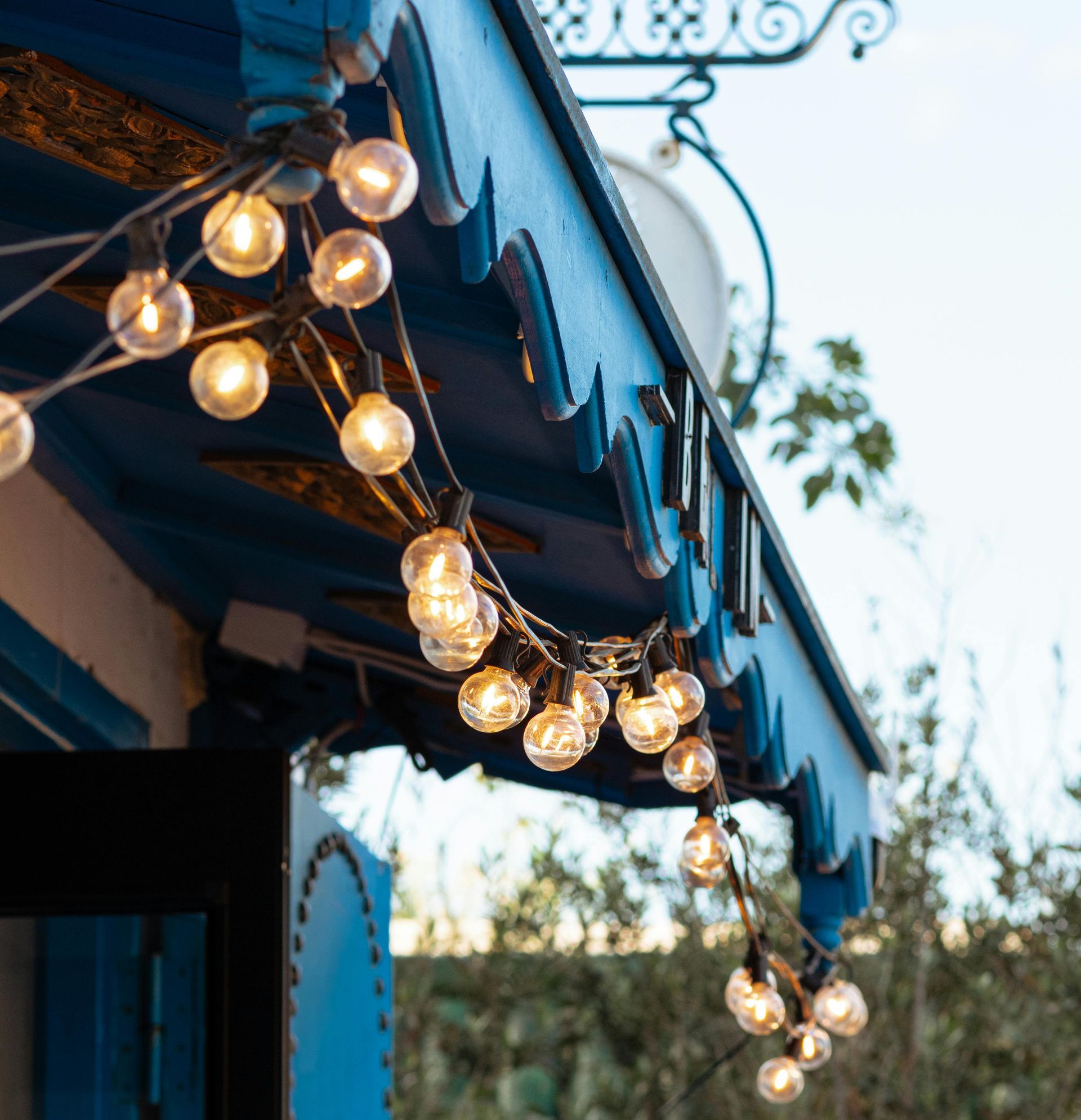 A string of lights hangs from the roof of a building