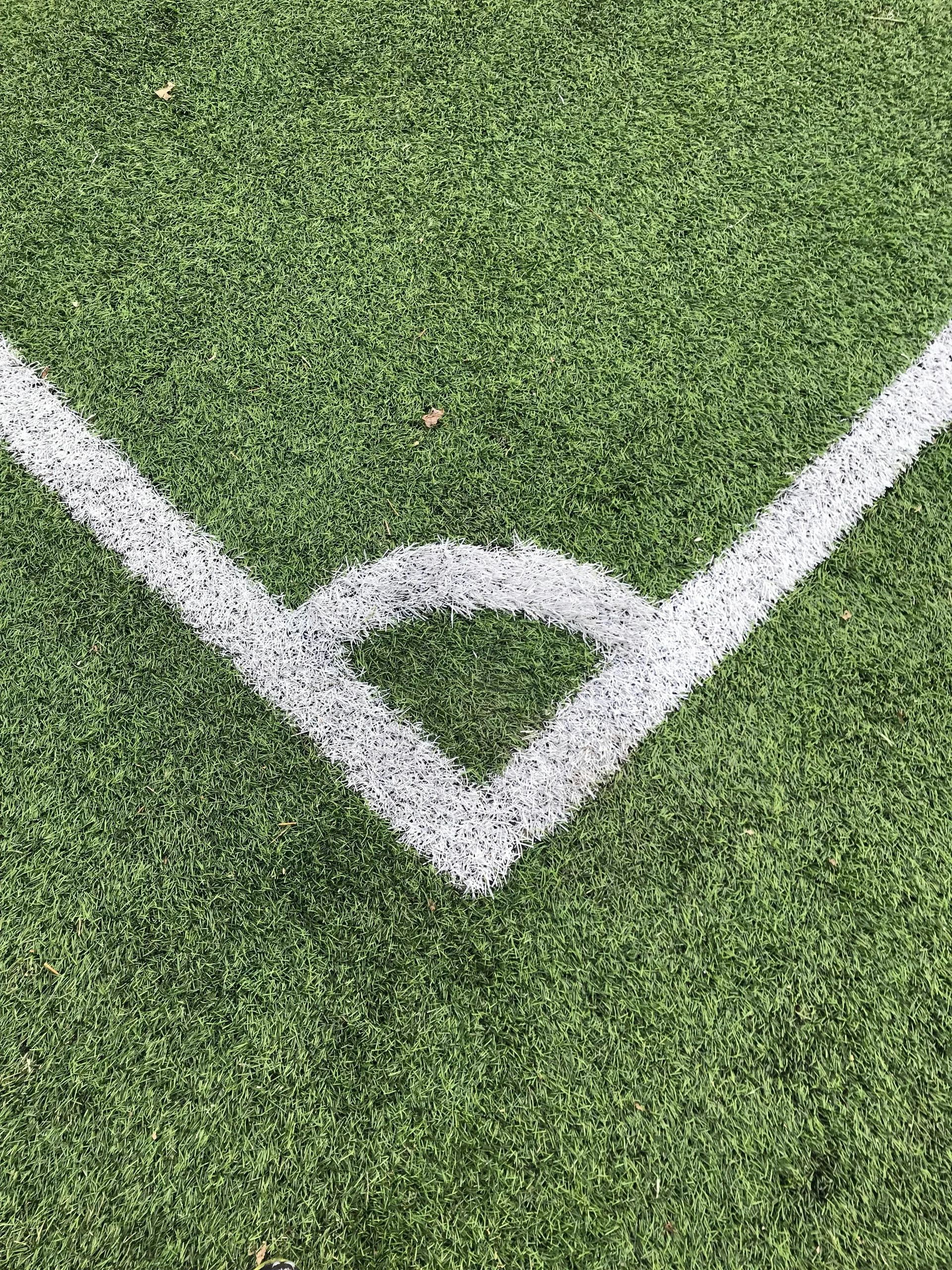 A white line is painted on the corner of a soccer field.