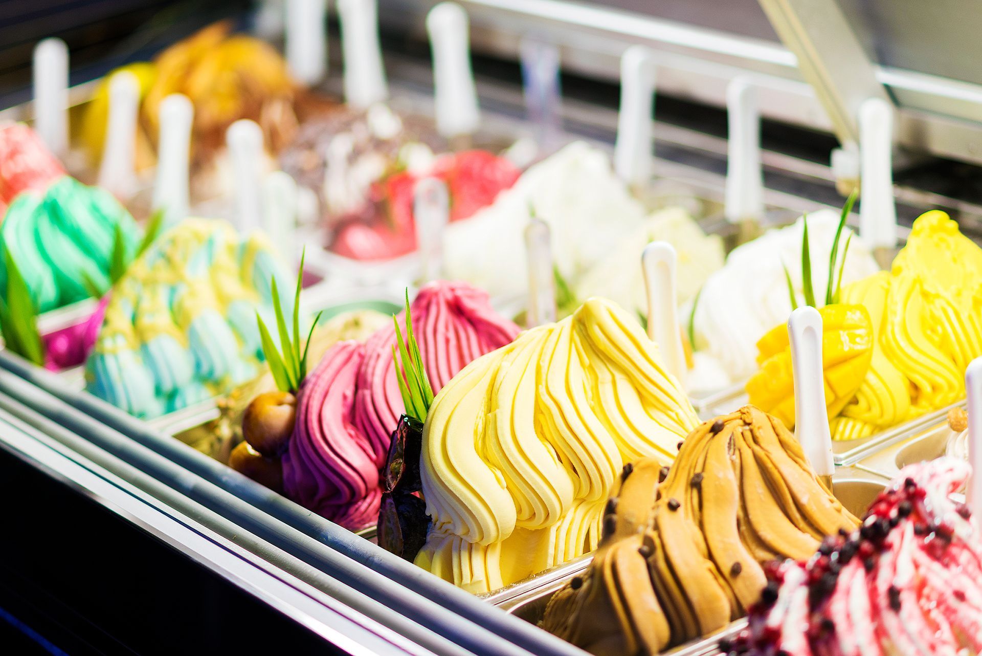 Une vitrine remplie de boules de gelato colorées et tourbillonnantes aux saveurs variées.