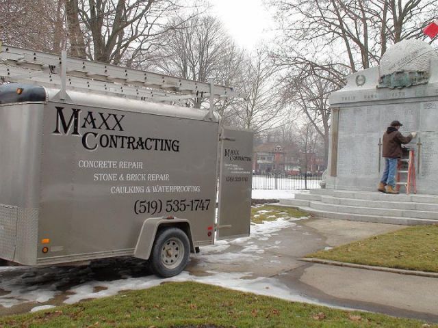 a maxx contracting truck is parked in front of a monument