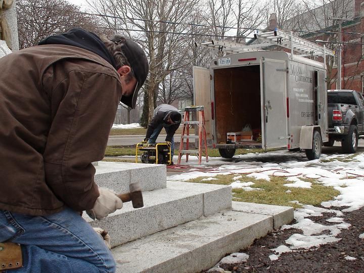 a man is working on stairs in front of a trailer that says mason construction