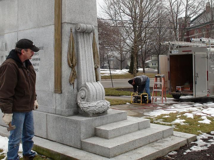 a man standing in front of a statue with the word justice on it