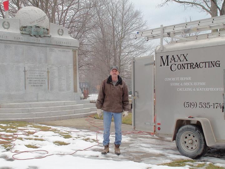 a man stands in front of a maxx contracting trailer