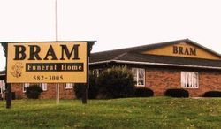 A funeral home with a sign in front of it.