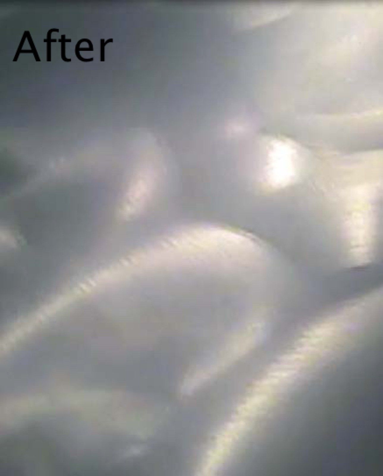 Polished metal surface with swirling light reflections.