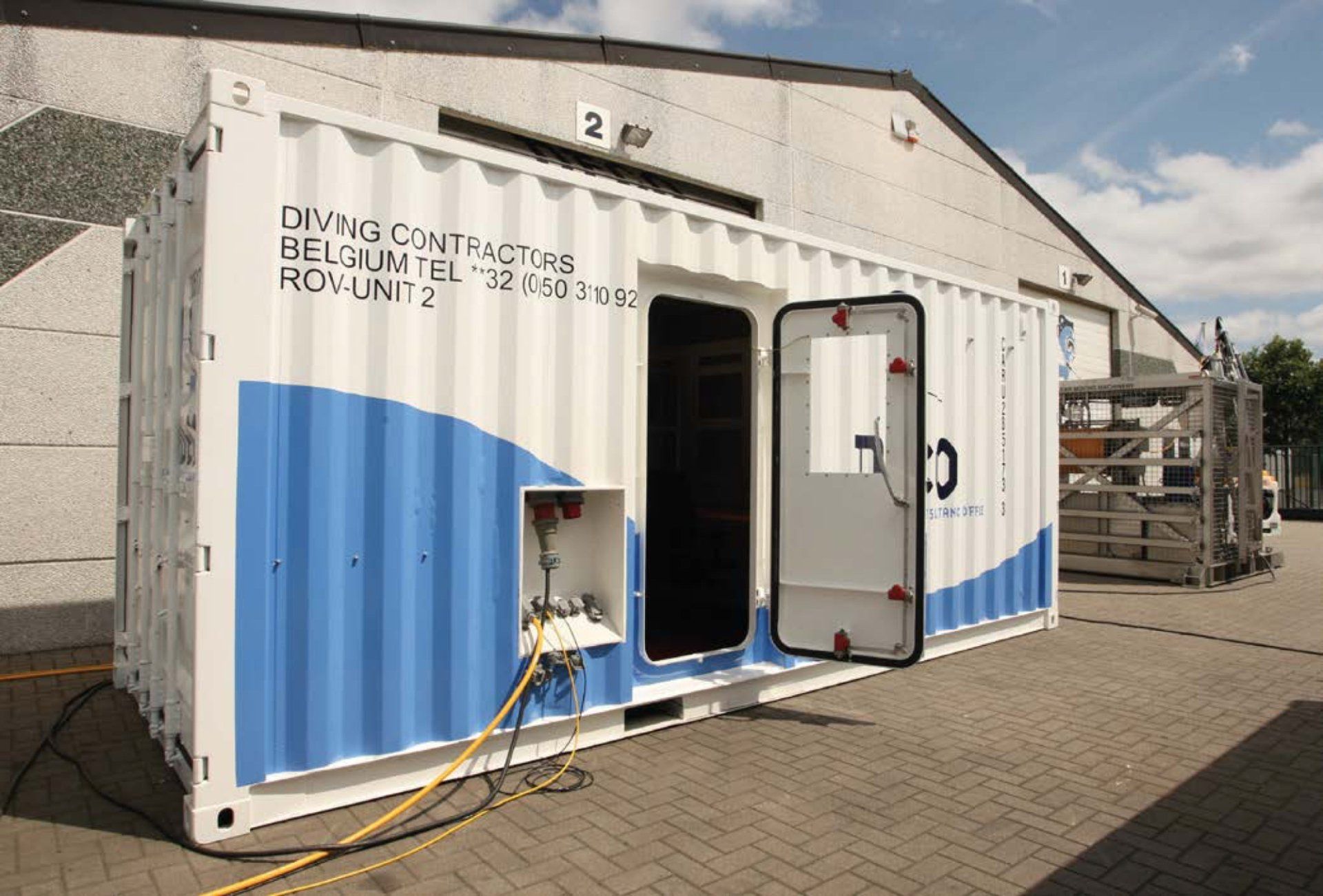 Shipping container modified with a door open, labeled 