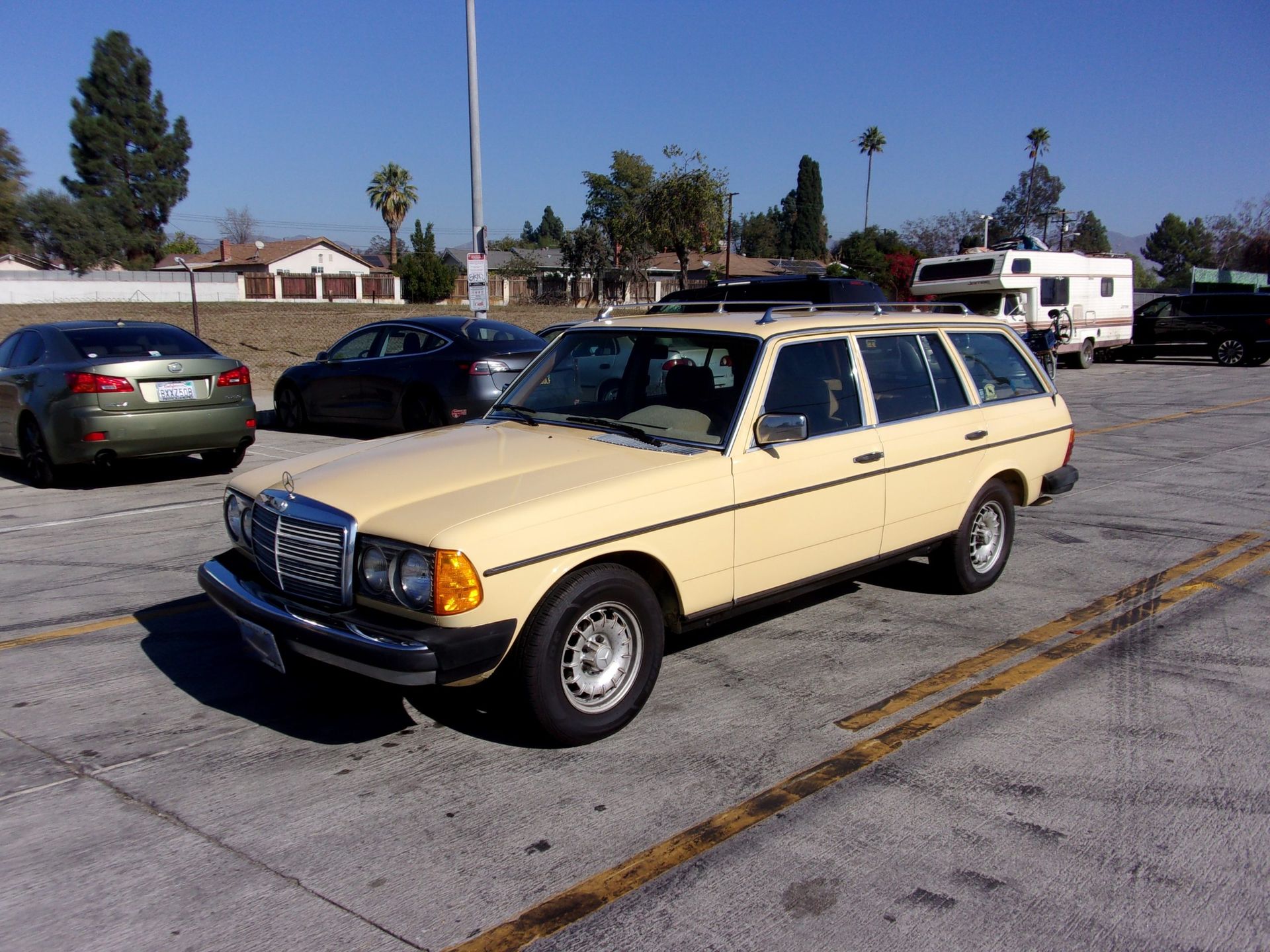 a yellow mercedes station wagon is parked in a parking lot and ready to install a pod rig for film shooting.