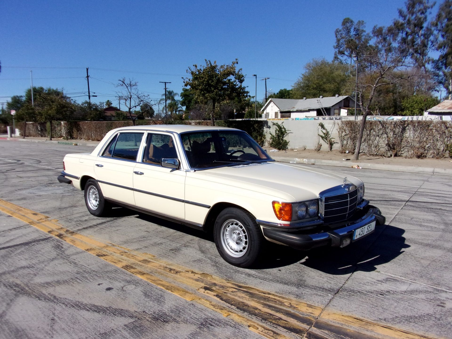 a white mercedes benz is parked in a parking lot and ready to install a pod rig for film shooting.