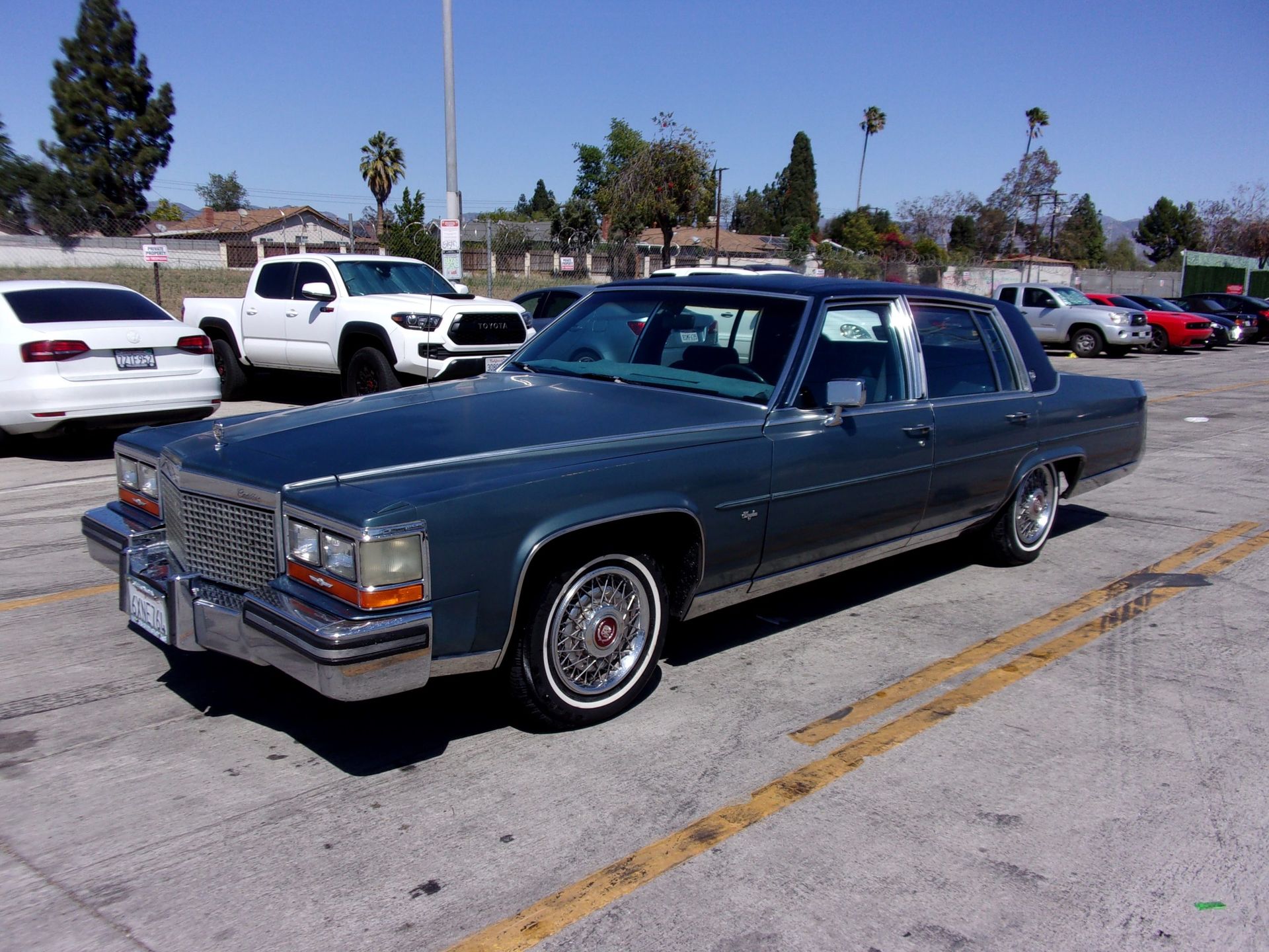 a blue cadillac is parked in a parking lot  and ready to install a pod rig for film shooting.