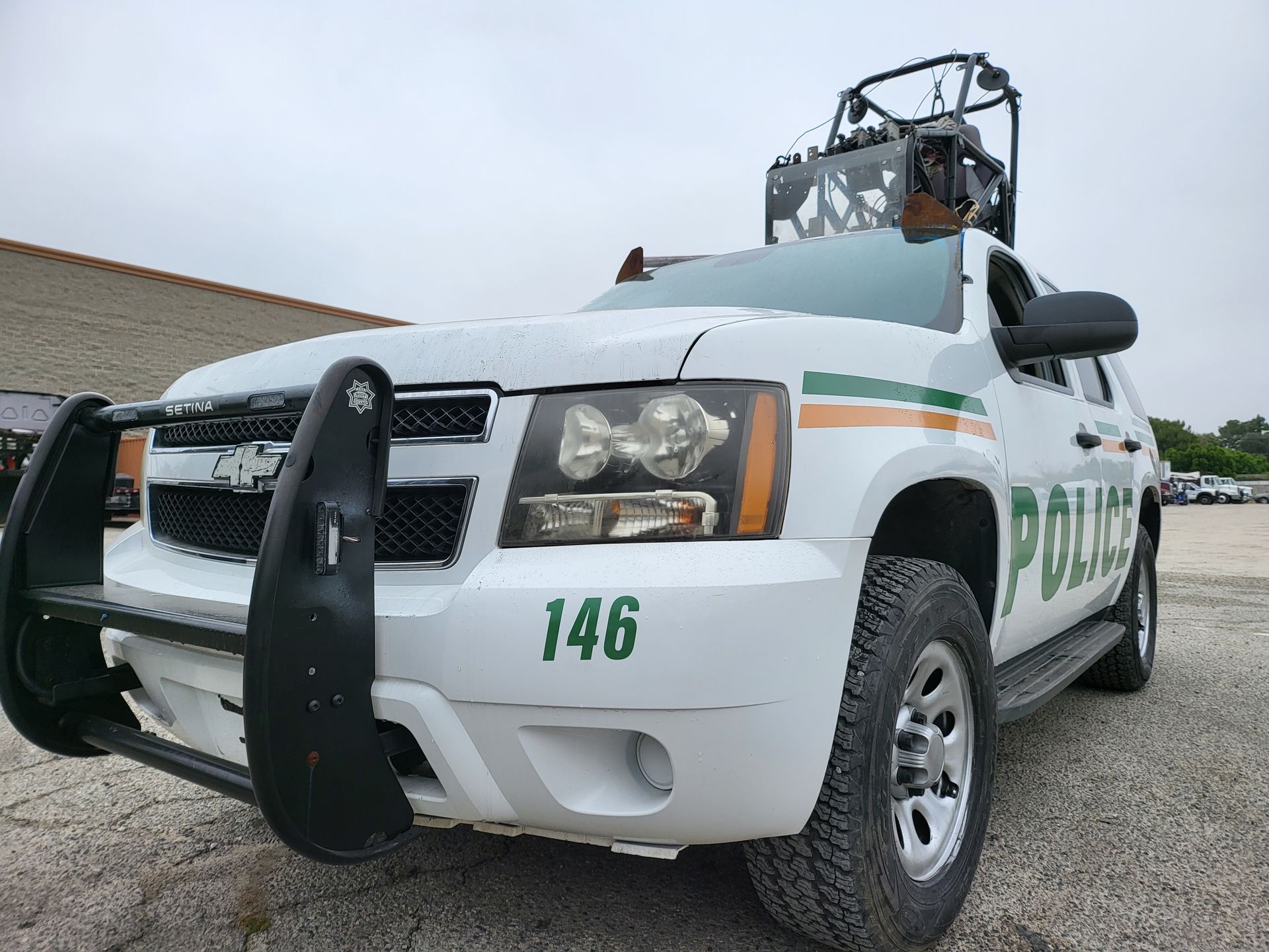a white police suv is parked in a parking lot with pod rigs on top of it for film shooting