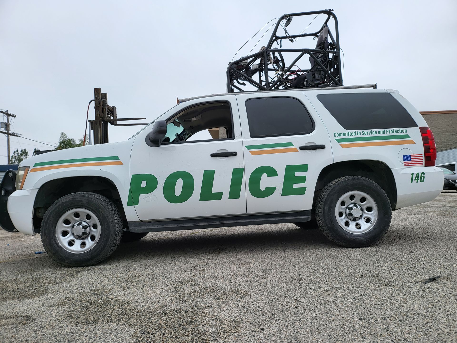 a white police suv is parked in a parking lot with pod rigs on top of it for film shooting