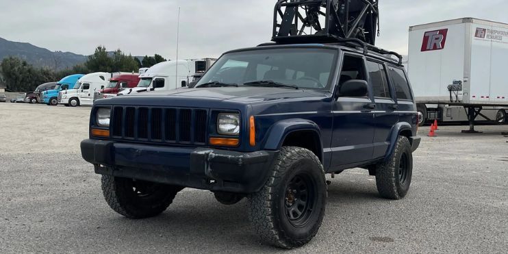 A Jeep Cherokee XJ 4x4 captured in action, showcasing its rugged design and off-road capabilities with dynamic camera angles.