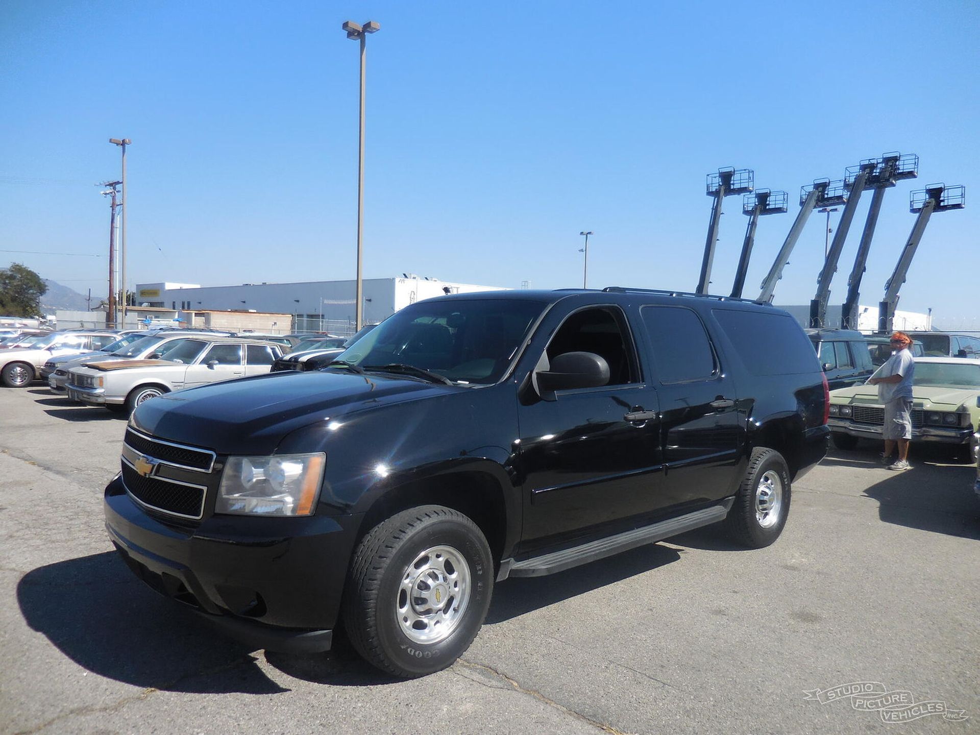 a black suv is parked in a parking lot and ready to install a pod rig for film shooting.