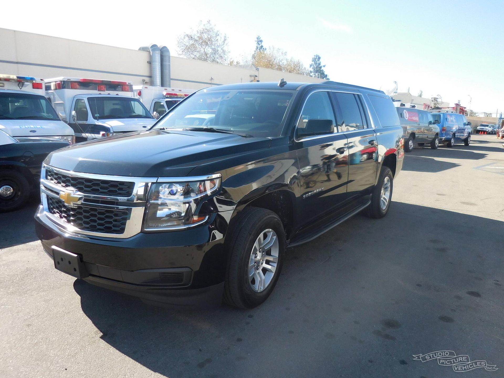 a black suv is parked in front of a fence and ready to install a pod rig for film shooting.