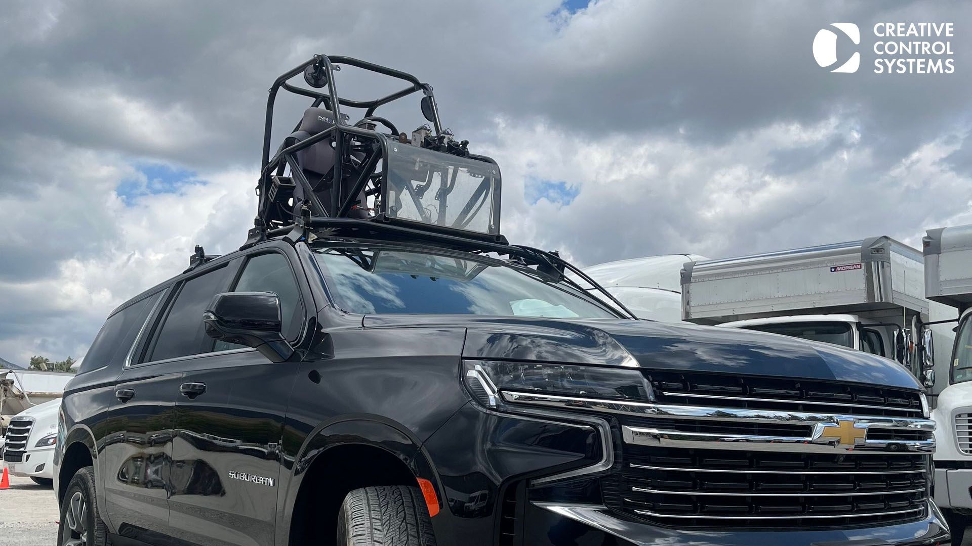 A black SUV equipped with a camera on its roof, enhancing precision and control for creative filming and scene development.