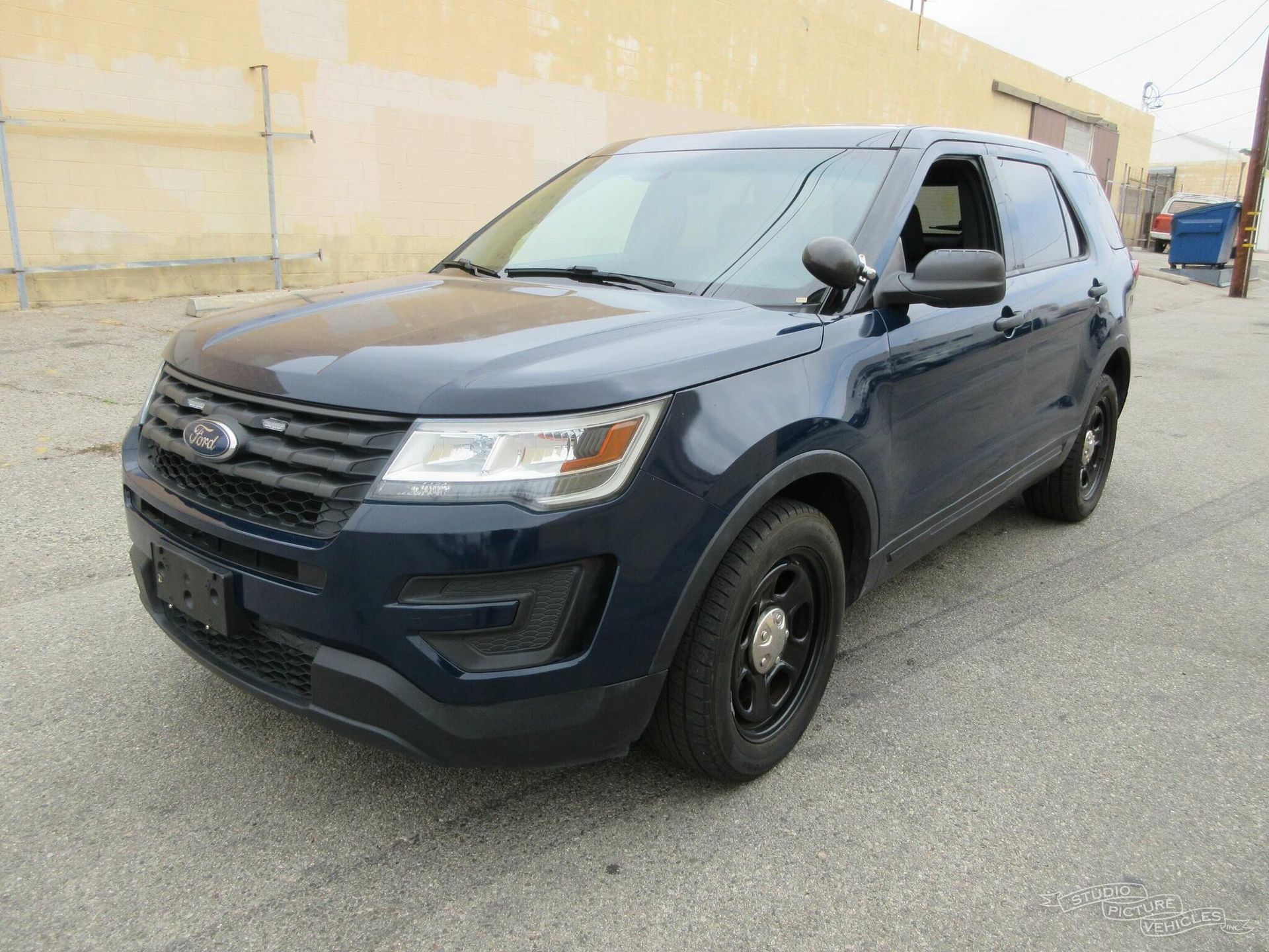a blue ford explorer police car is parked and ready to install a pod rig for film shooting.