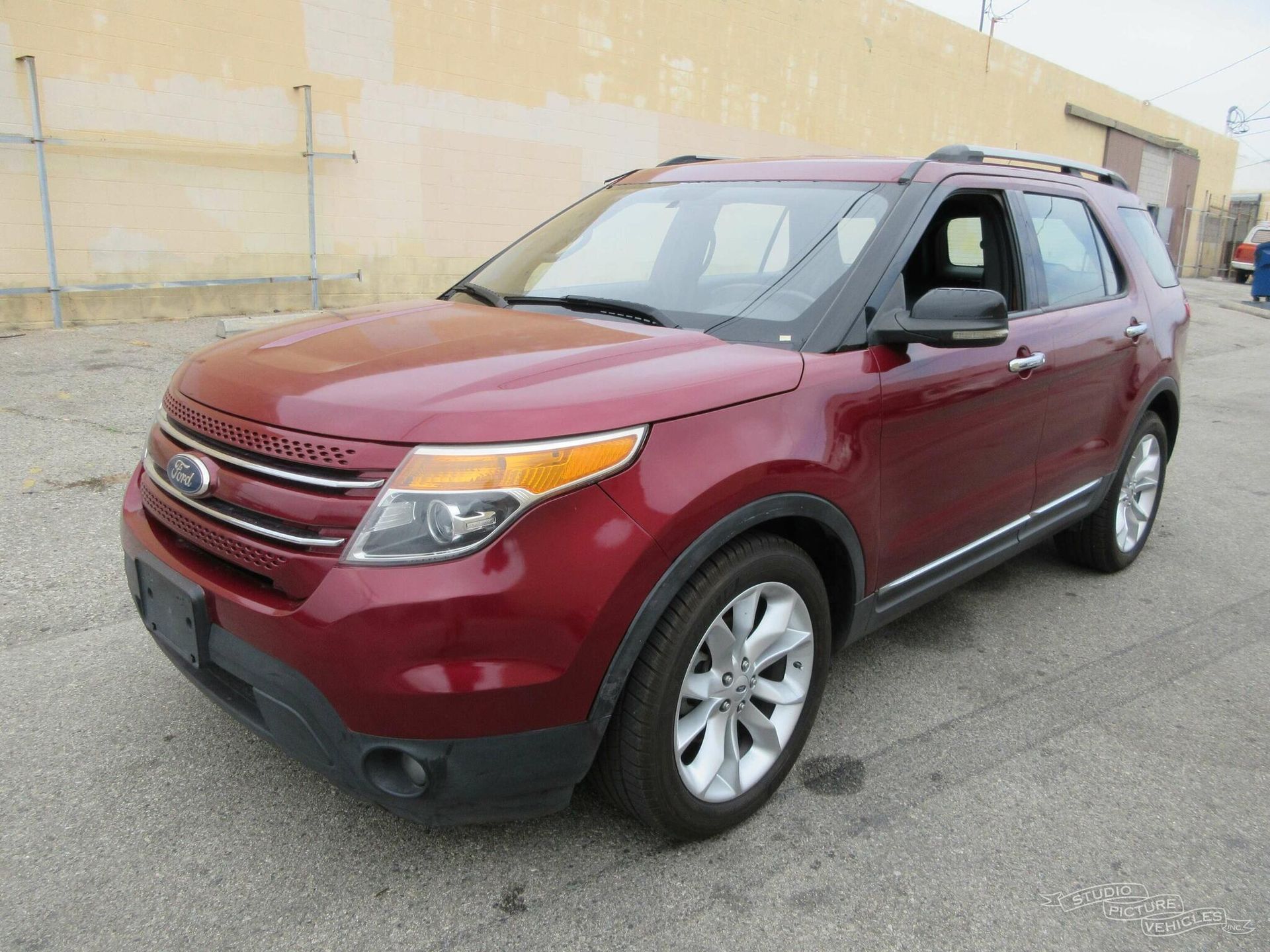 A red Ford Explorer is parked and ready to install a pod rig for film shooting.