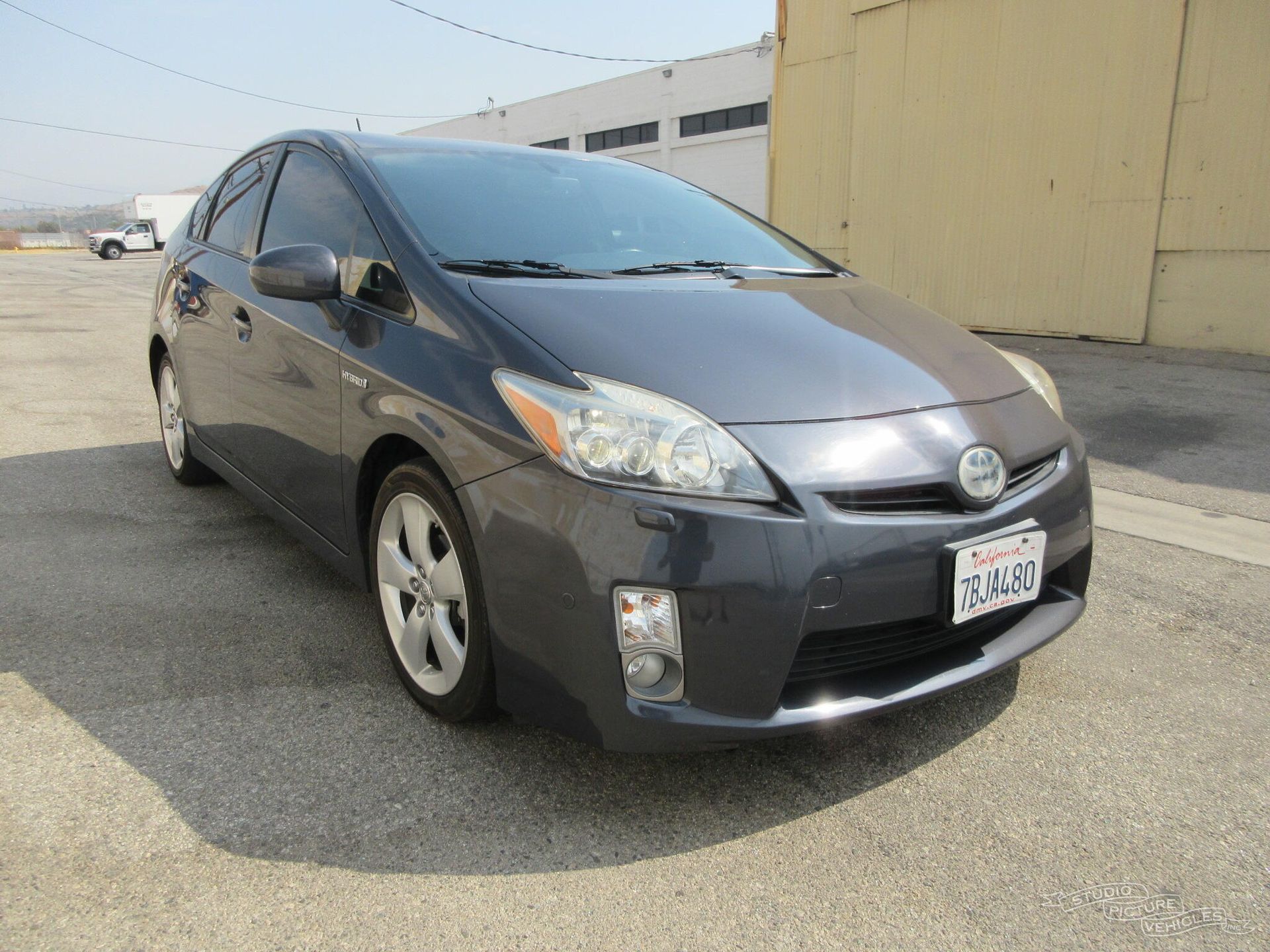 A gray toyota prius is parked in front of a building and ready to install a pod rig for film shooting.