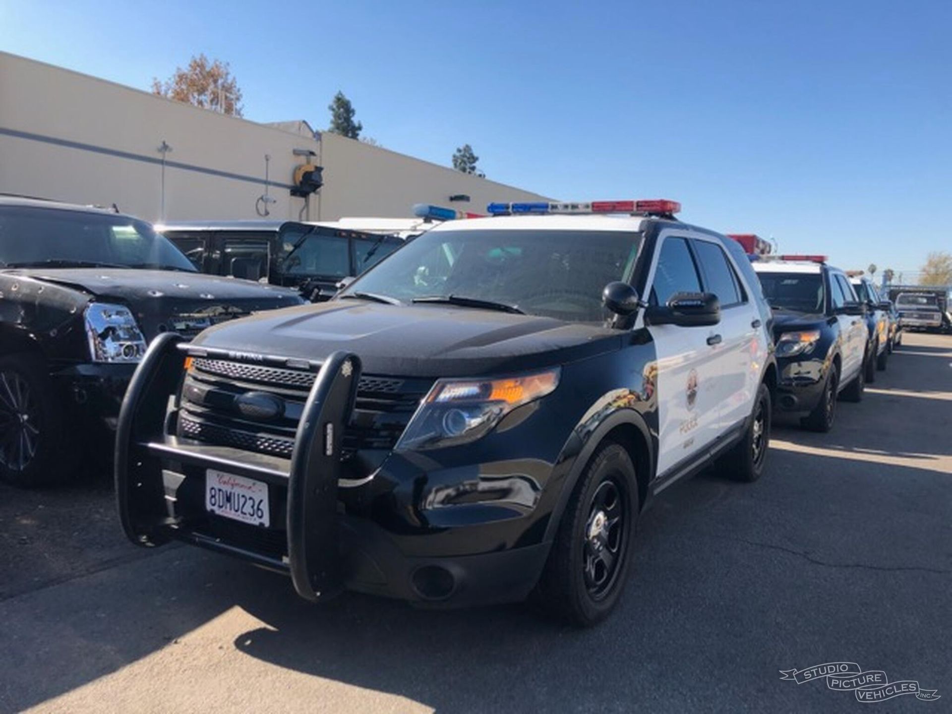 A black and white police car is parked and ready to install pod rigs for film shooting.