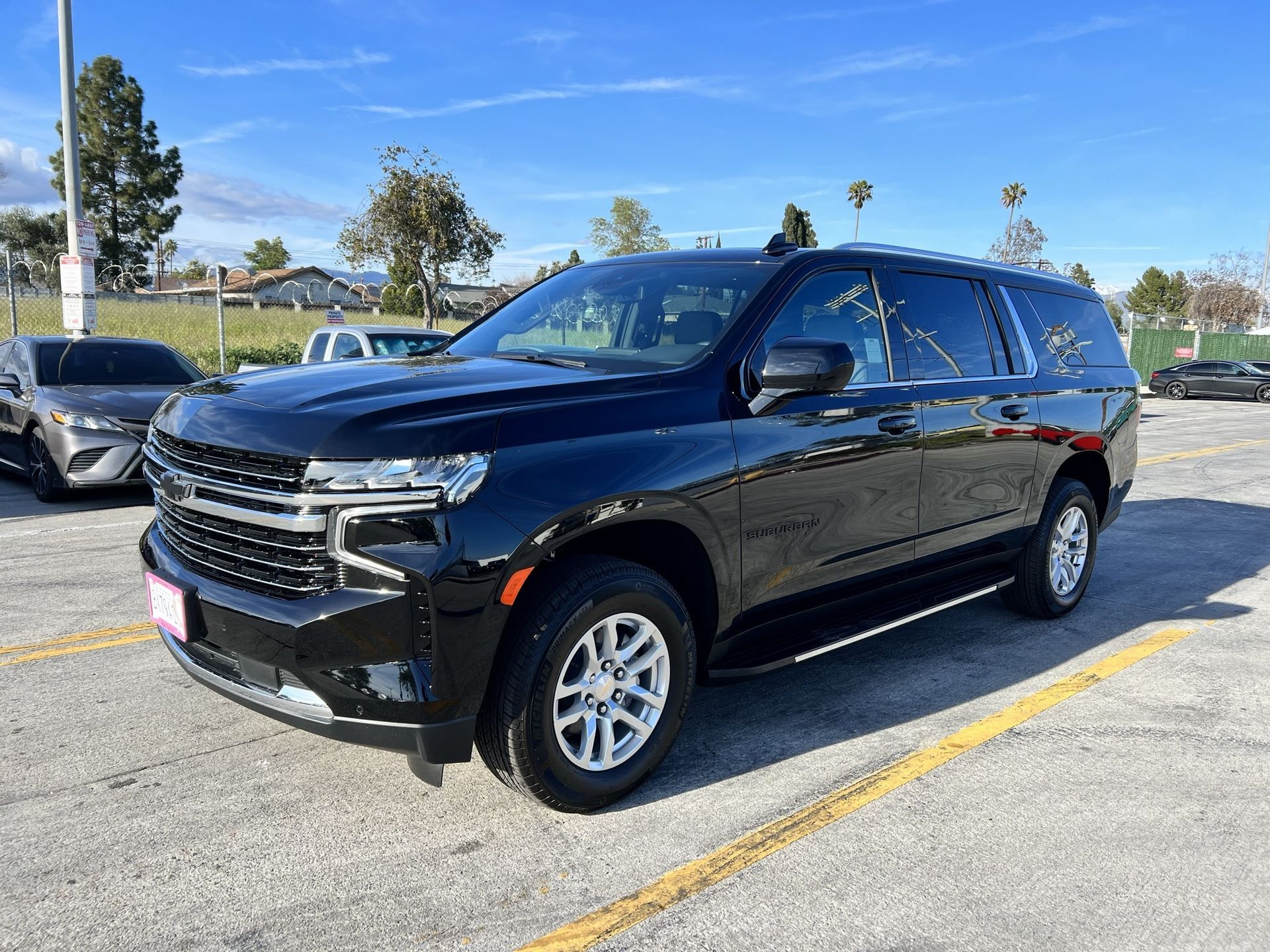 a black suv is parked in front of a fence and ready to install a pod rig for film shooting.