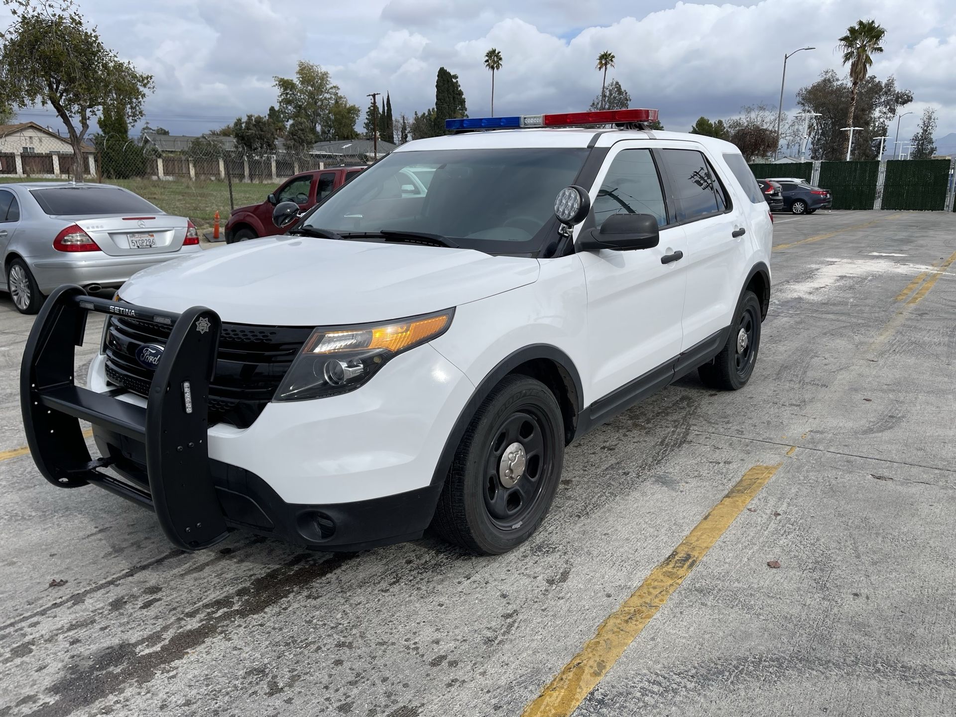 A white car is parked and ready to install pod rigs for film shooting.