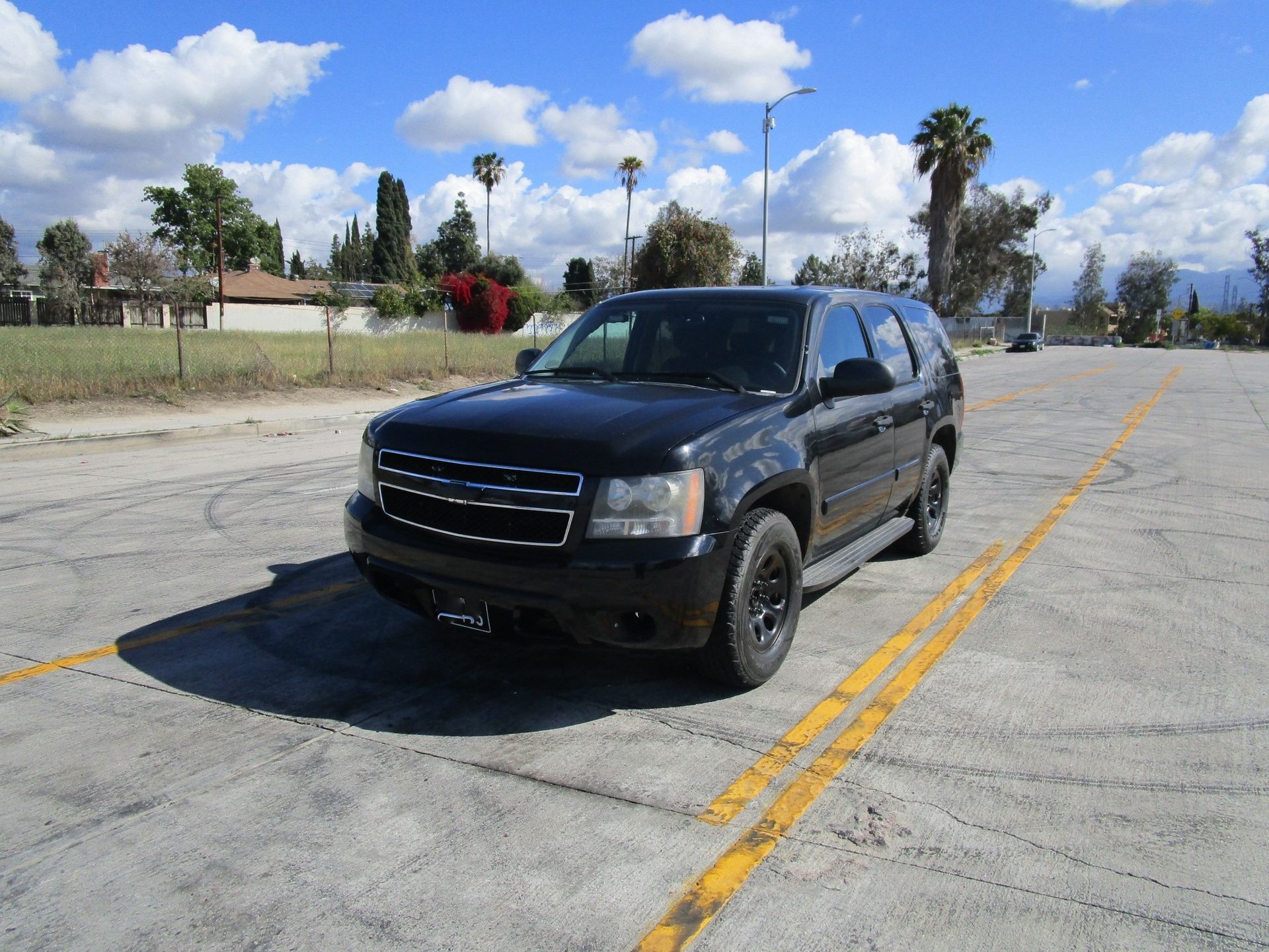 a black suv is parked in front of a fence and ready to install a pod rig for film shooting.