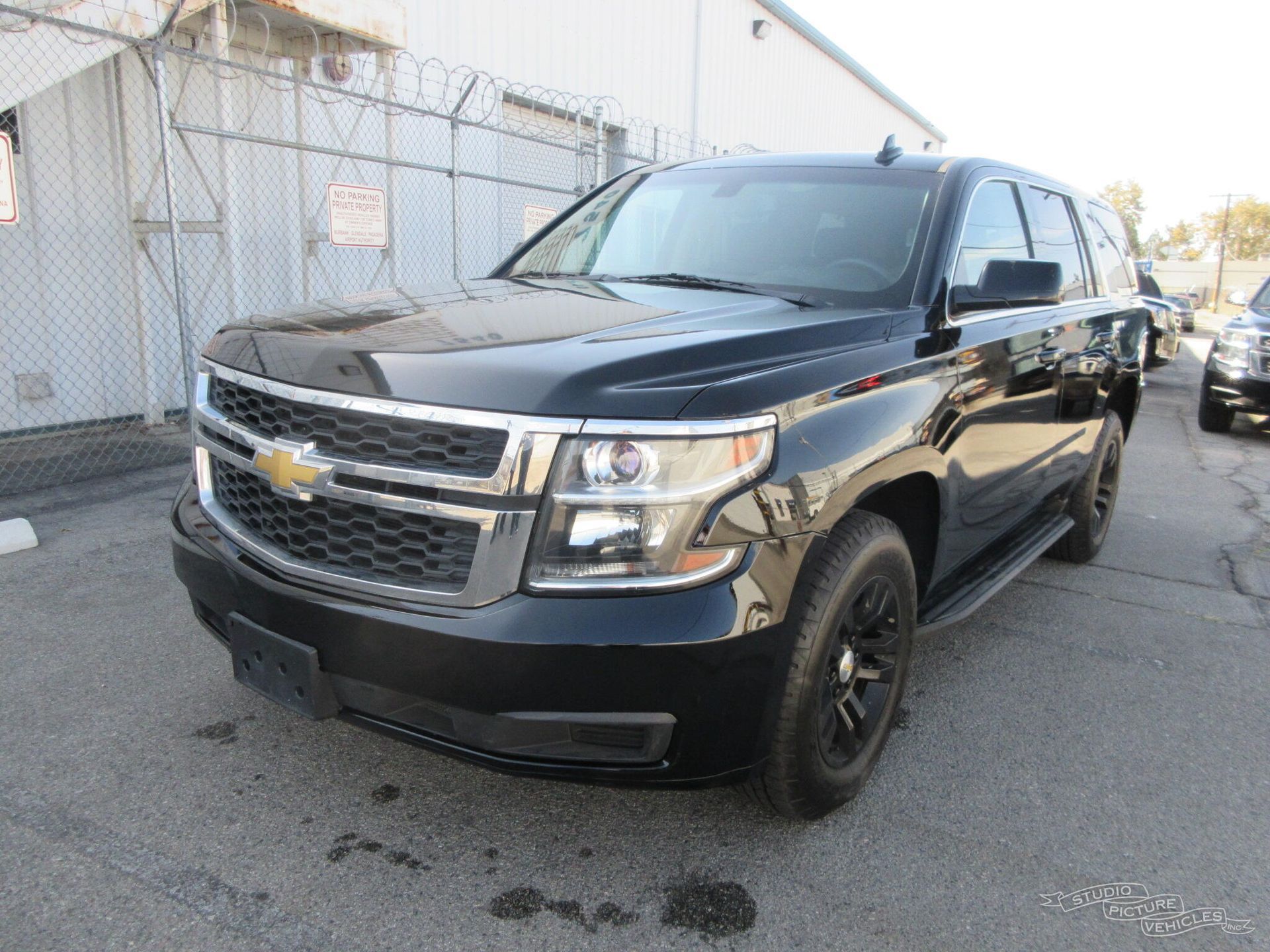 a black chevrolet tahoe is parked in front of a building .