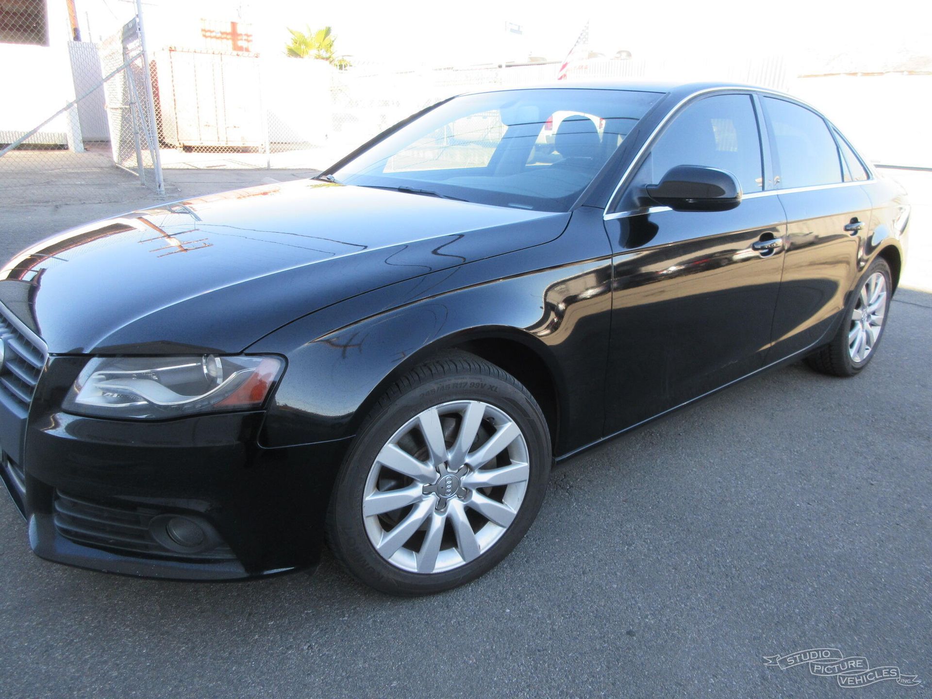 a black audi a4 is parked on the side of the road and ready to install a pod rig for film shooting.