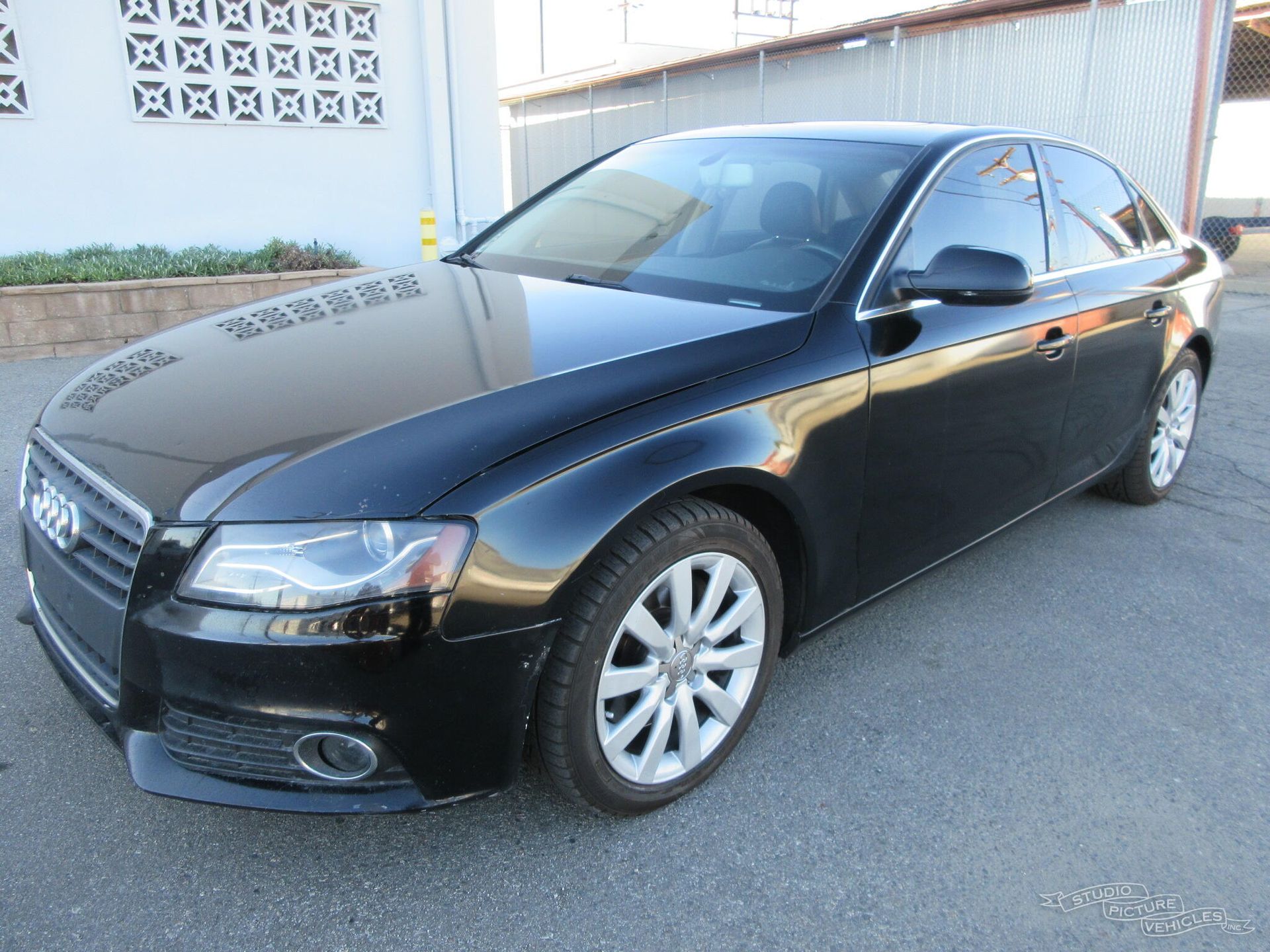 a black audi a4 is parked on the side of the road and ready to install a pod rig for film shooting.