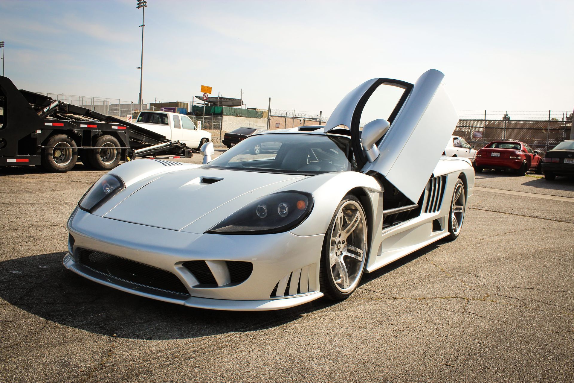 Need for Speed car - Silver sports car with open gullwing doors parked on asphalt.