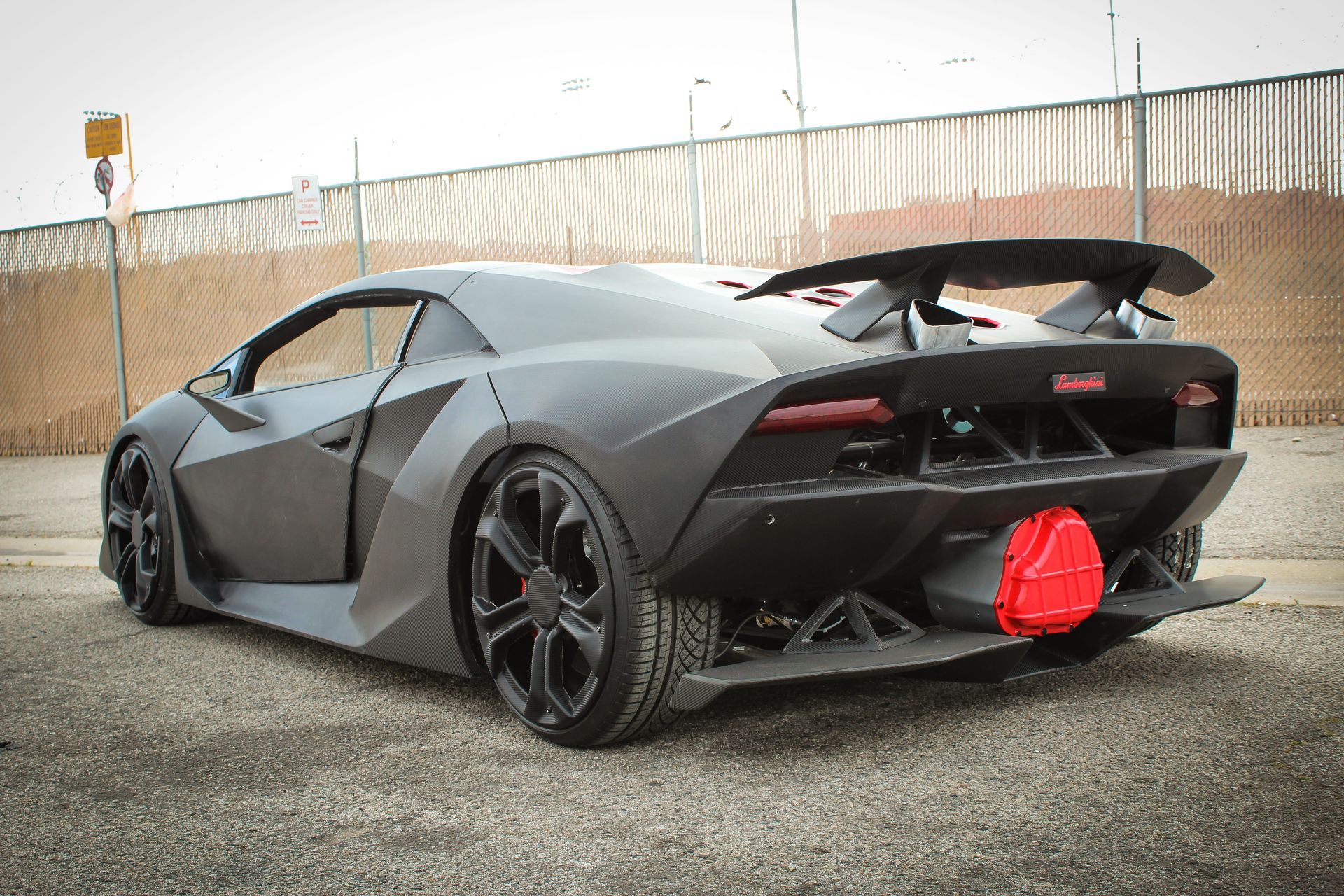 Need for Speed car - Matte gray Lamborghini Sesto Elemento sports car, rear view. Large spoiler, black wheels, red exhaust.