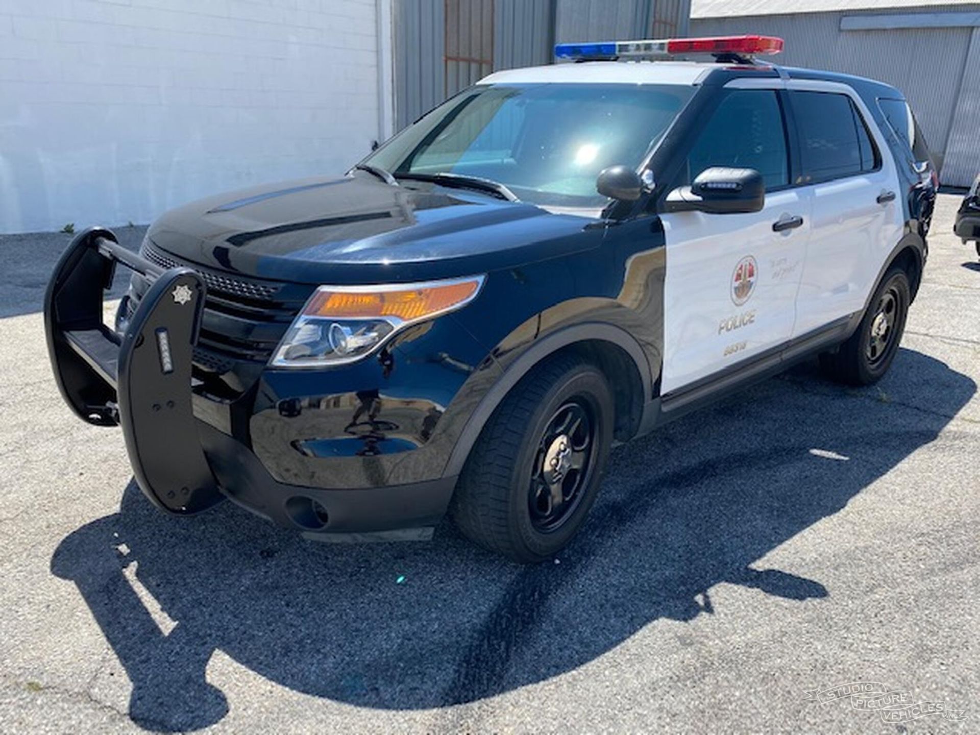 A black and white car is parked and ready to install pod rigs for film shooting.